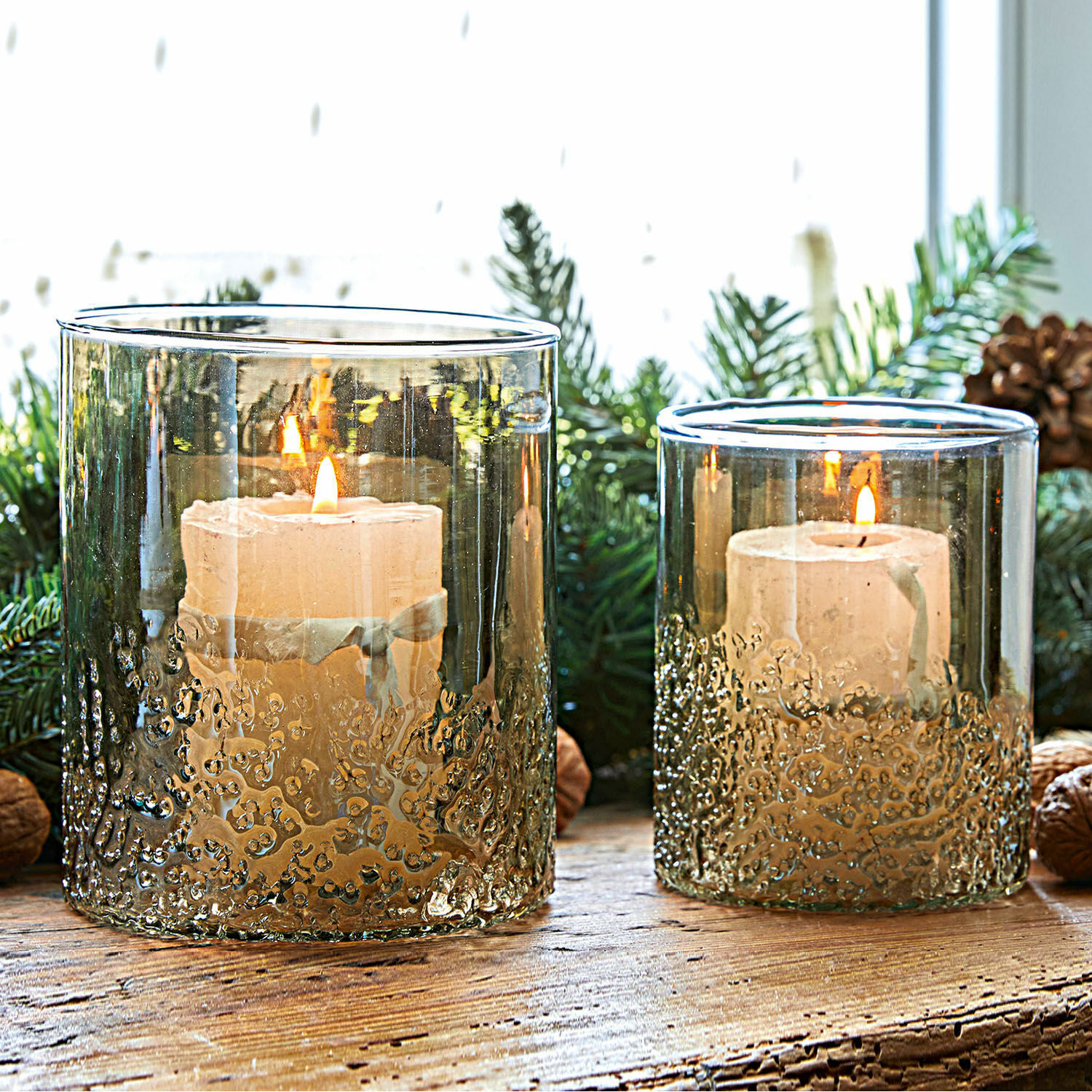 Coppia di portalumini Plélo Portacandele in vetro fumé con texture e candele bianche su tavolo in legno rustico