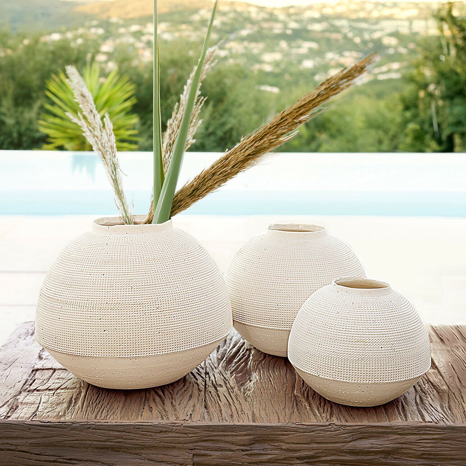 Set di 3 vasi Émoliane Set di tre vasi rotondi in ceramica beige su tavolo in legno, decorazione d'interni elegante