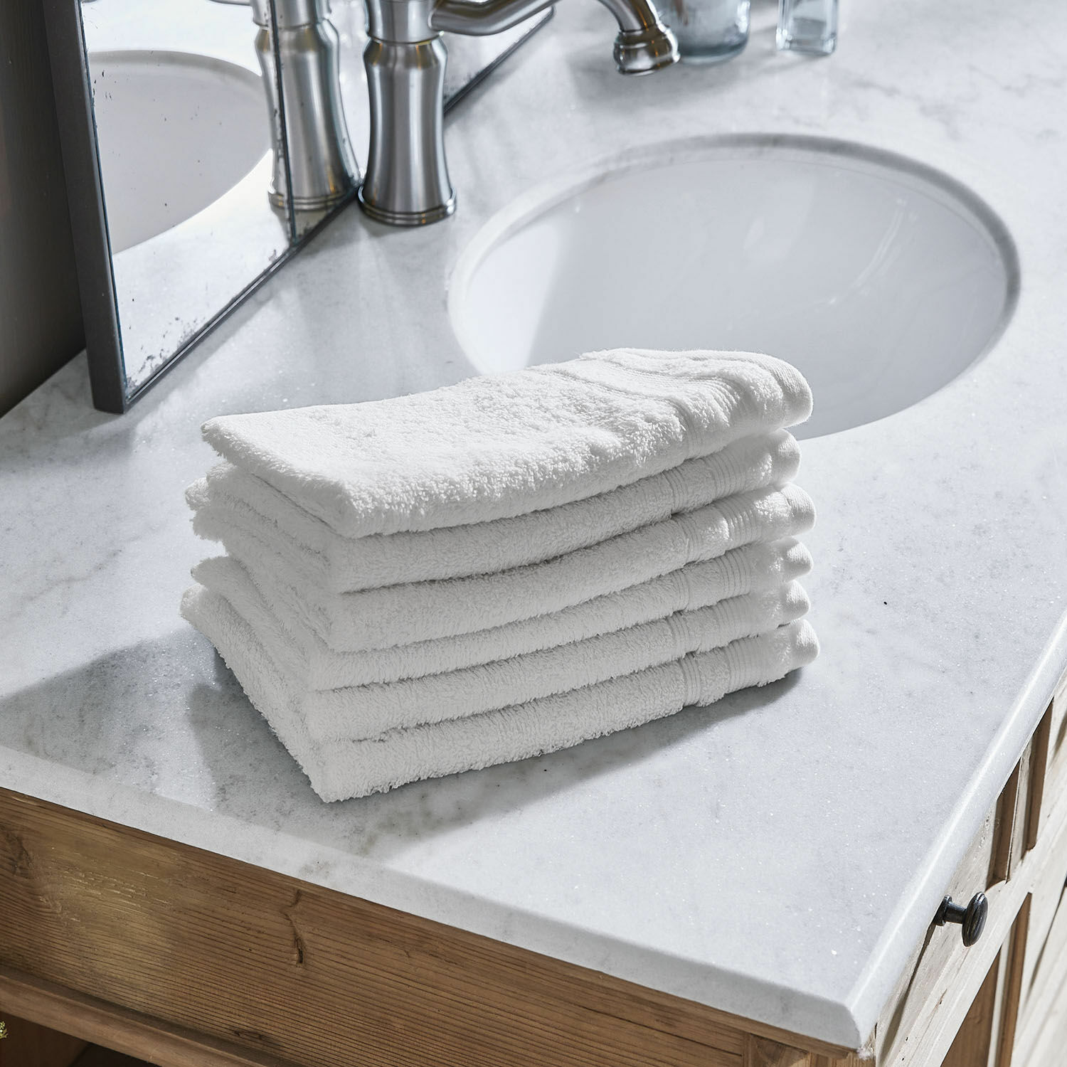 Set di 6 asciugamani per gli ospiti Bourogne Mucchio di asciugamani bianchi in cotone su lavabo in marmo con mobile in legno in bagno