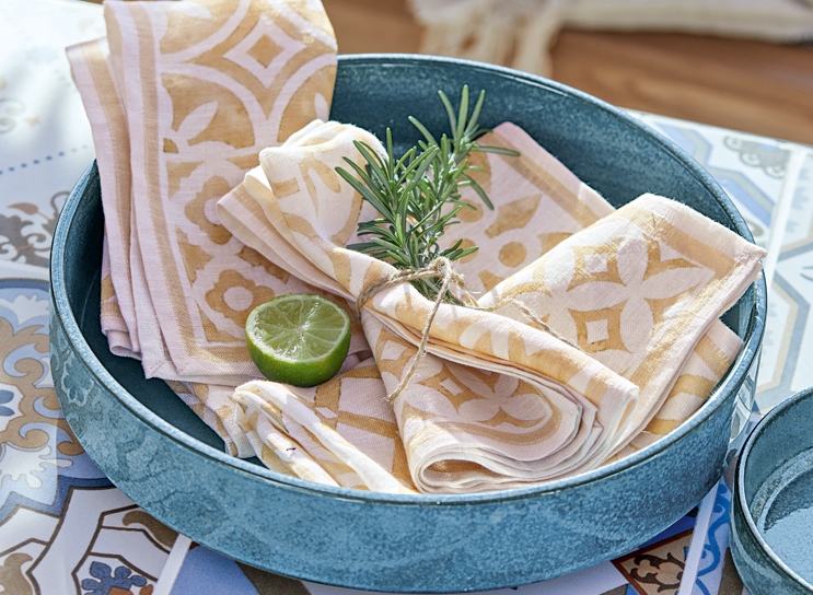 Ciotola in ceramica blu con tovaglioli di lino beige e bianco e fetta di lime, stile mediterraneo