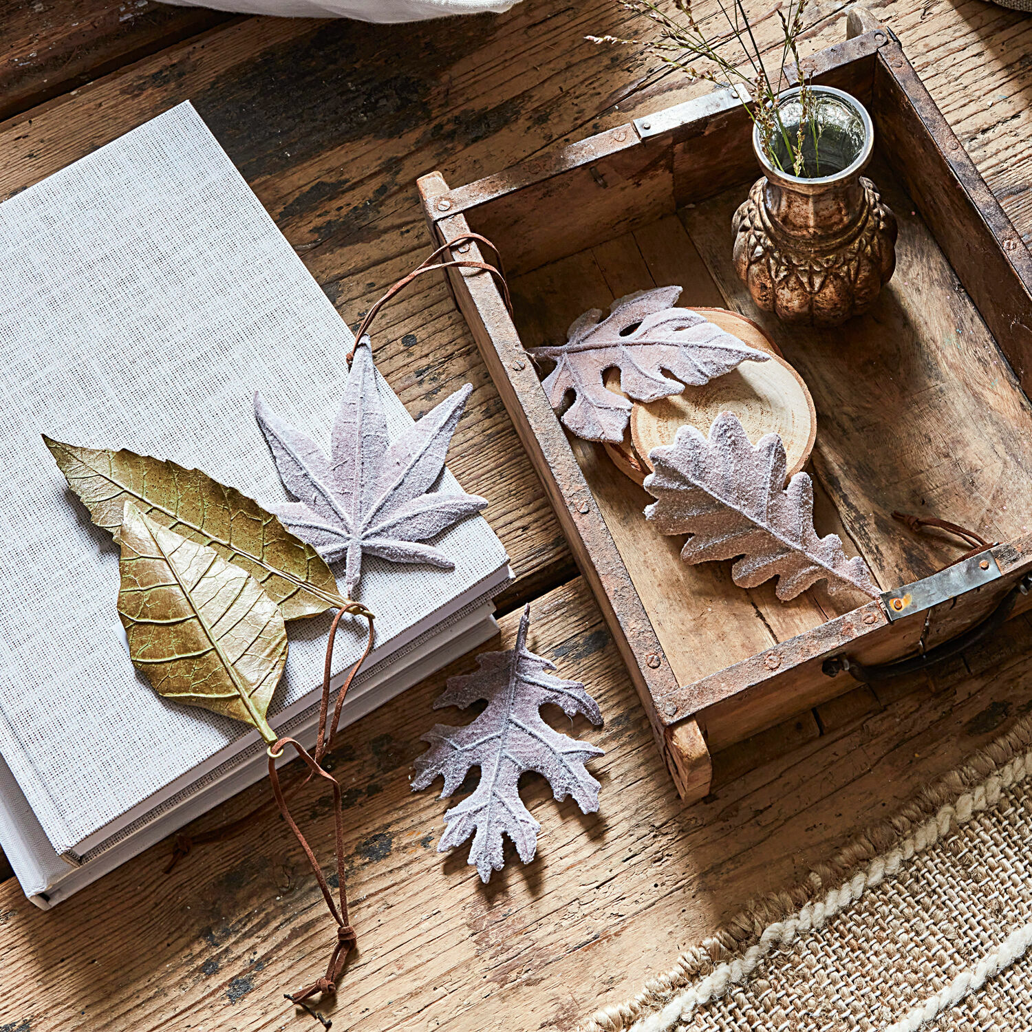 Set di 6 foglie Merel Foglie decorative dorate e grigie su tavolo in legno con libro e vassoio rustico