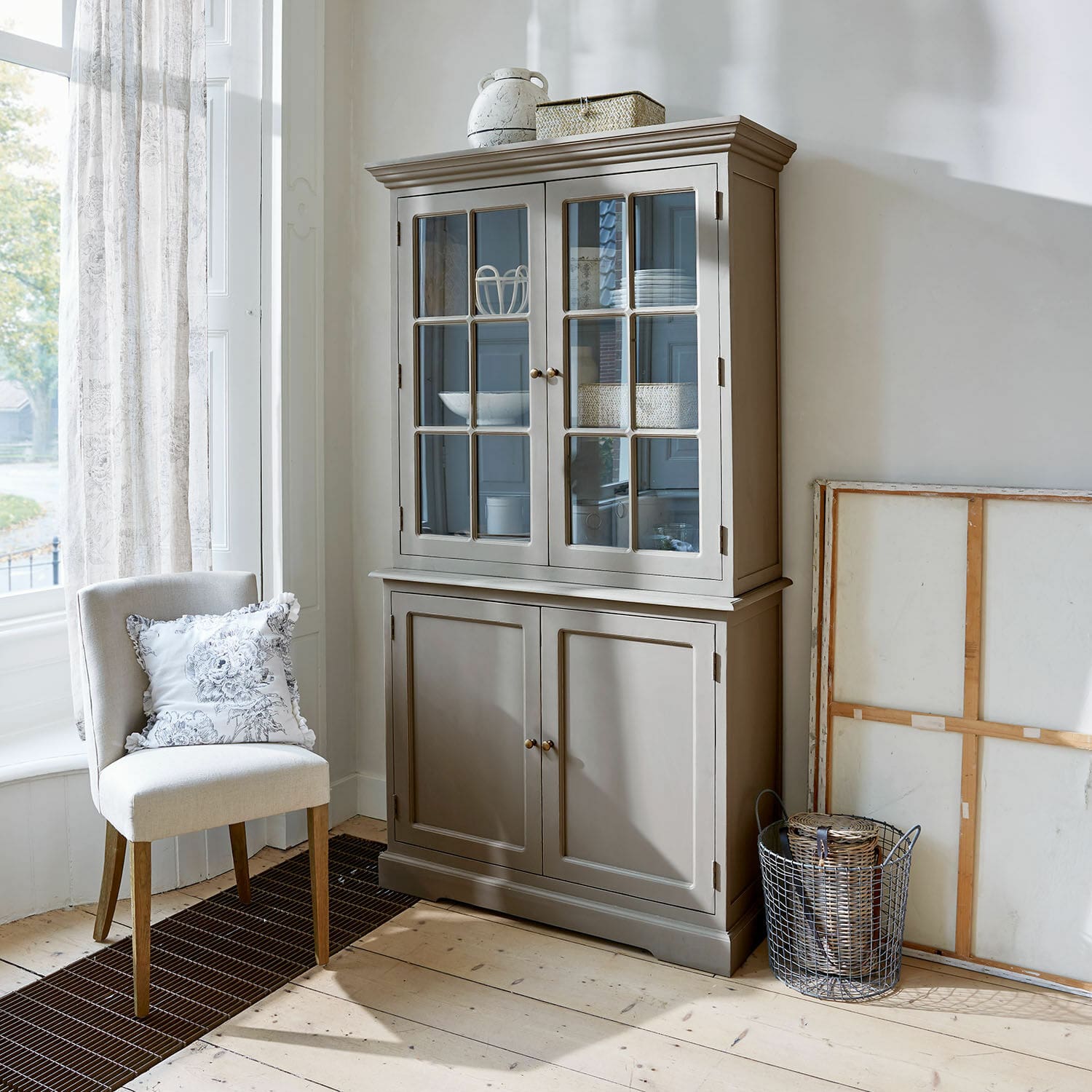 Credenza Rosebrook Vetrina in legno grigia con ante in vetro e ripiani in soggiorno luminoso