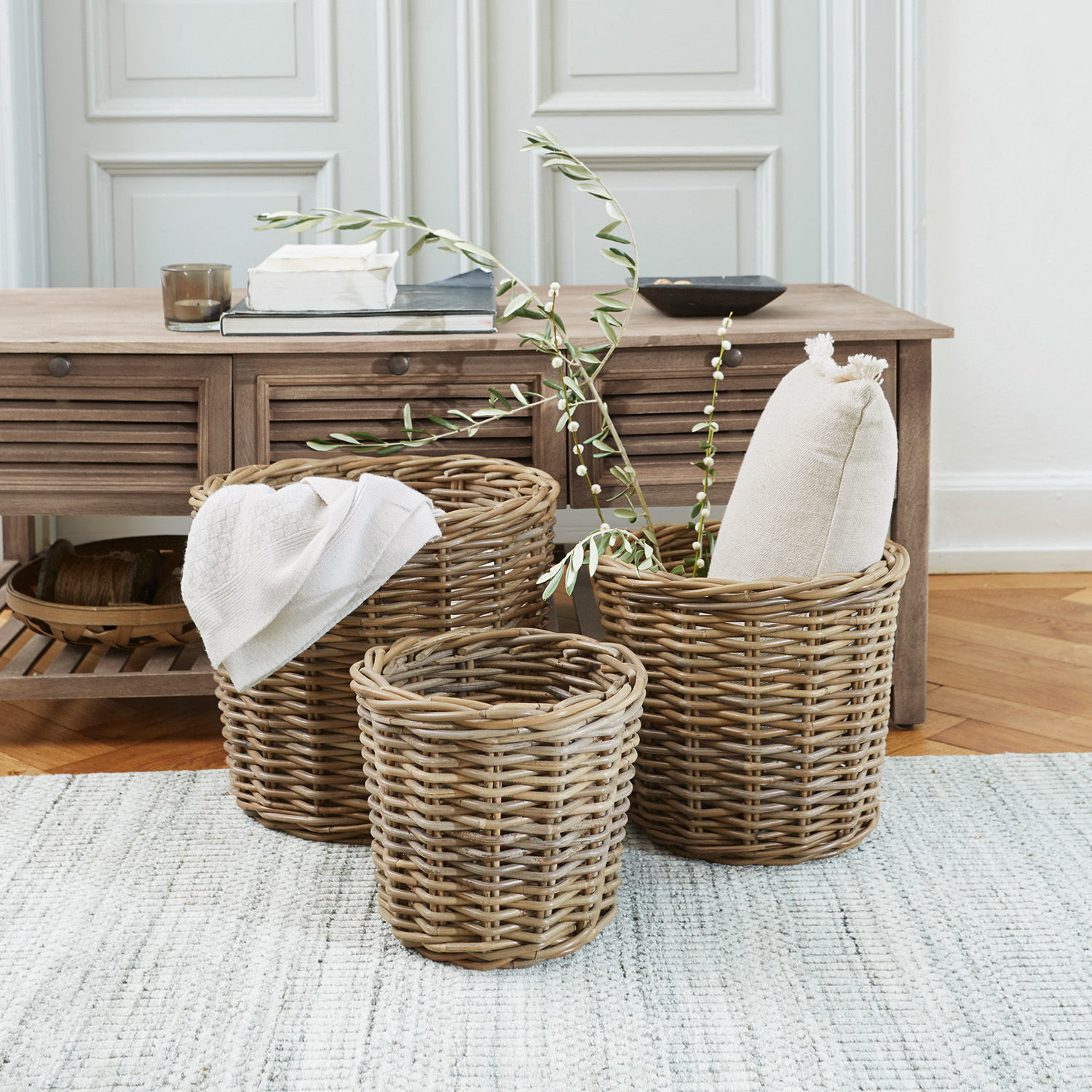Set di 3 cesti Avar Set di tre cesti in vimini colore naturale per conservare in casa su tappeto chiaro.