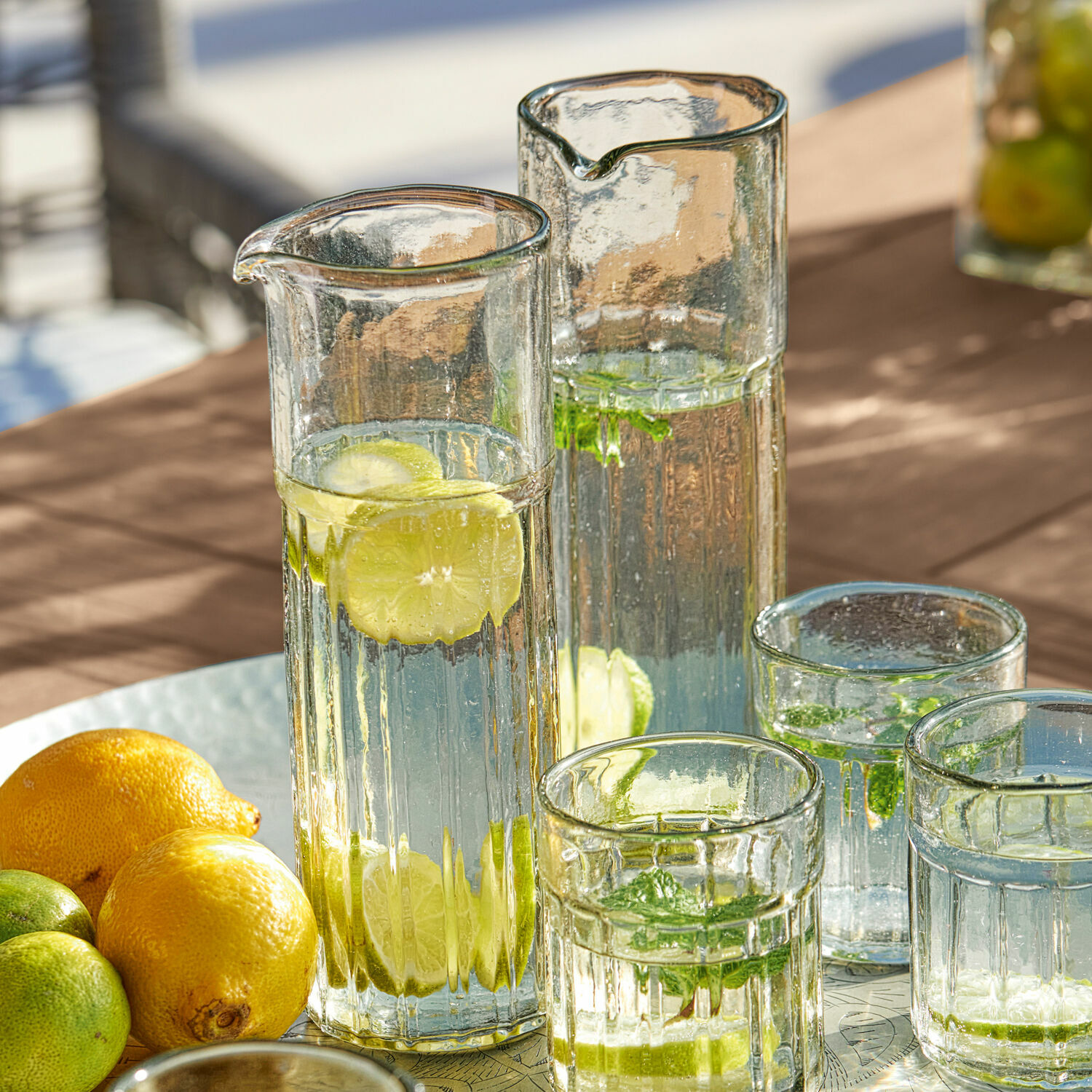 Coppia di caraffe Roseville Brocche e bicchieri di vetro con acqua, limone e menta su tavolo, bevanda estiva rinfrescante