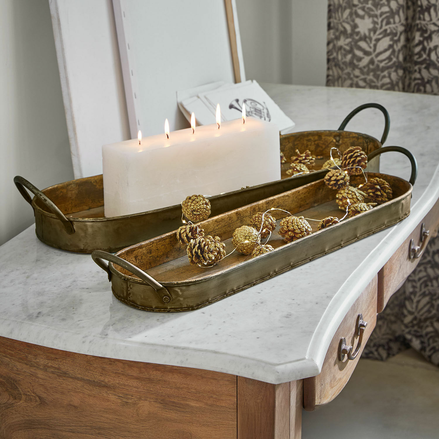 Coppia di vassoi Célianne Vassoio decorativo in metallo dorato su piano in marmo con candela bianca e decorazioni di pigne