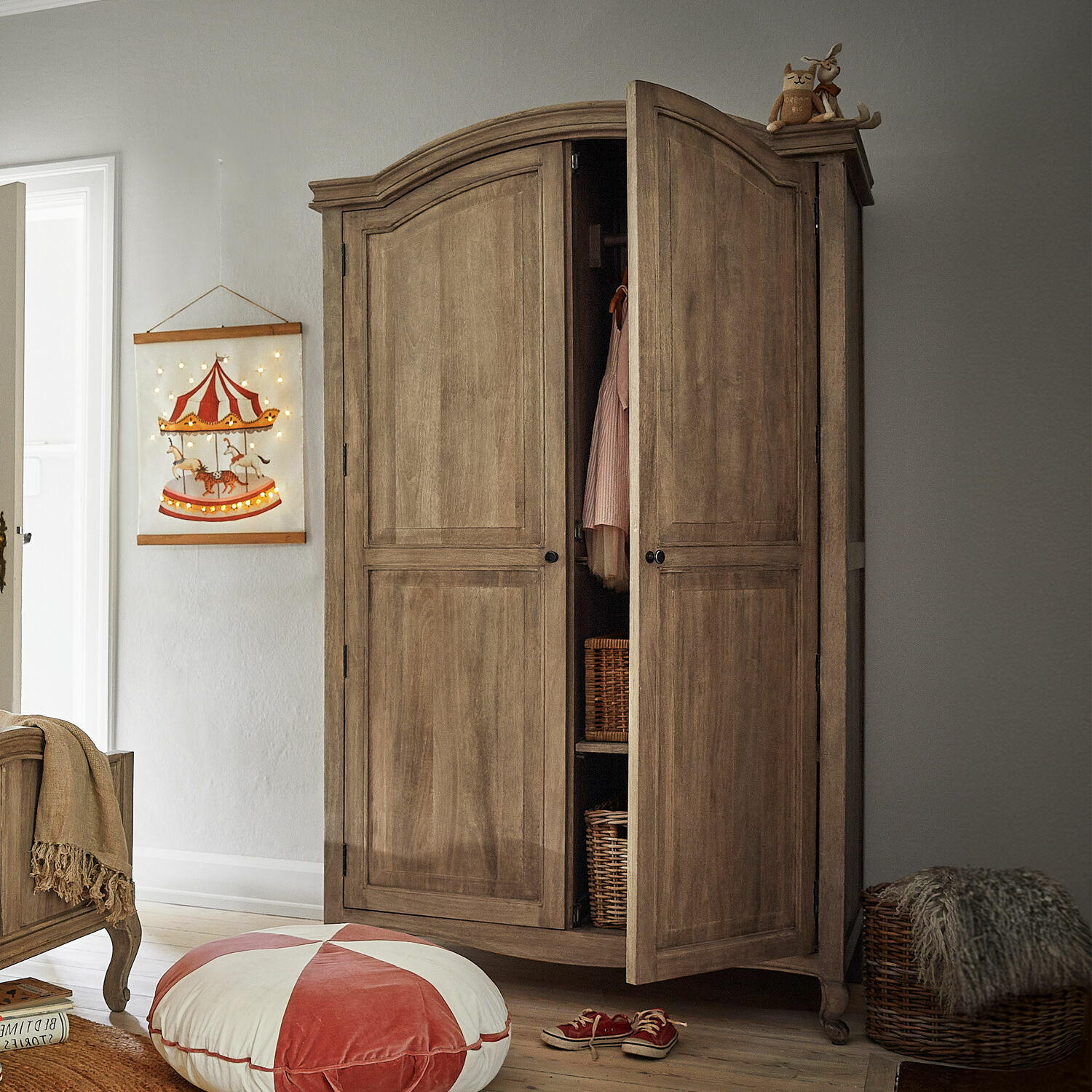 Armadio Éveilou Armadio in legno colore naturale con ante aperte, cesti di vimini e decorazioni in camera per bambini
