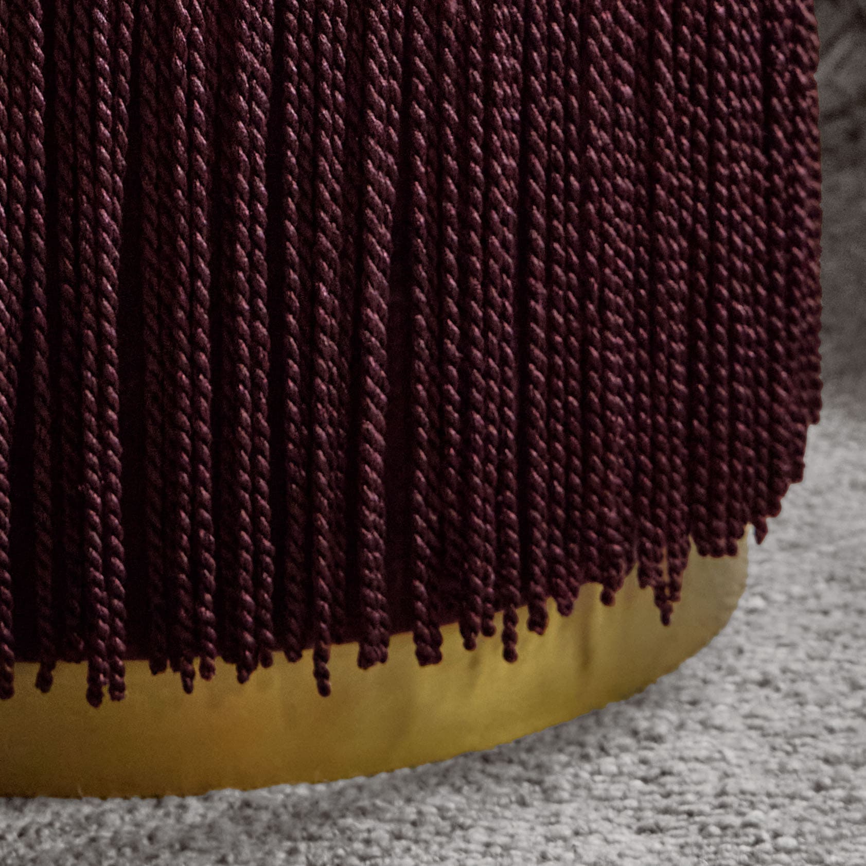 Materiale intrecciato bordeaux su sfondo giallo su tappeto grigio, texture tessile decorativa
