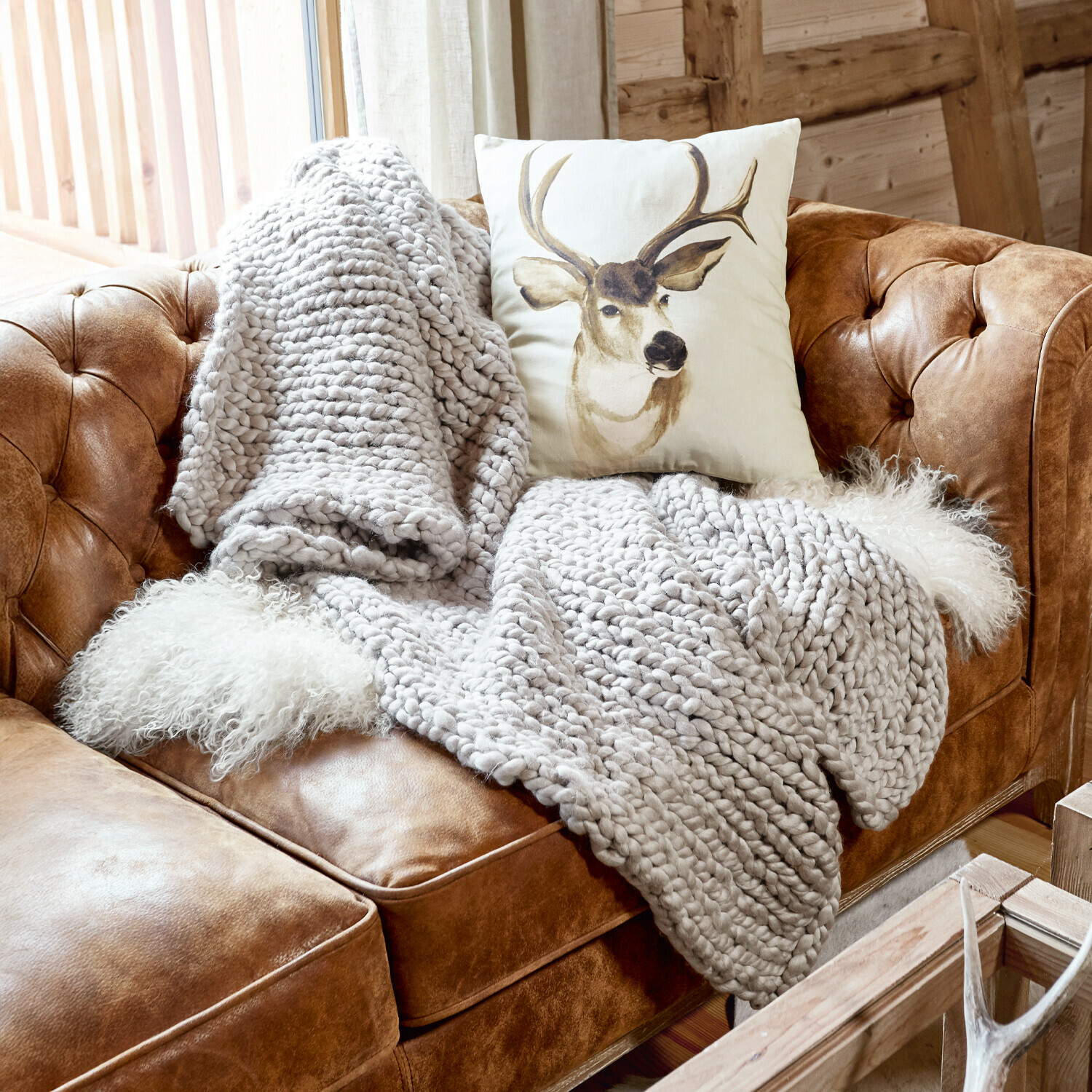 Coperta Reidous Divano in pelle marrone con coperta spessa grigia e cuscino con cervo in interno rustico