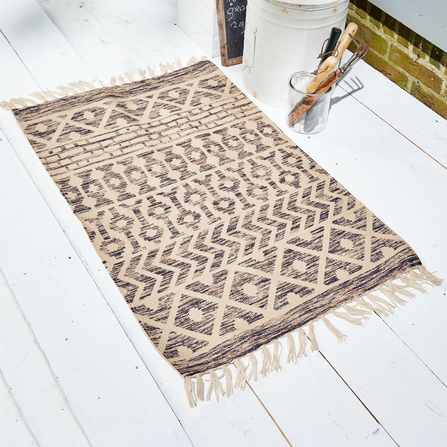Stuoino per interni ed esterni Champigny Tappeto beige con motivo geometrico e frange su pavimento bianco, decorazione d'interni