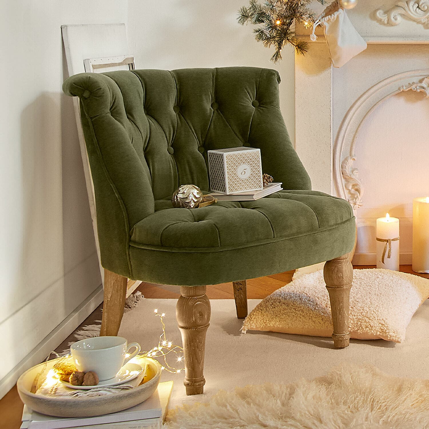 Poltrona Ardilleux Poltrona verde in velluto con gambe in legno in ambiente accogliente con decorazioni natalizie