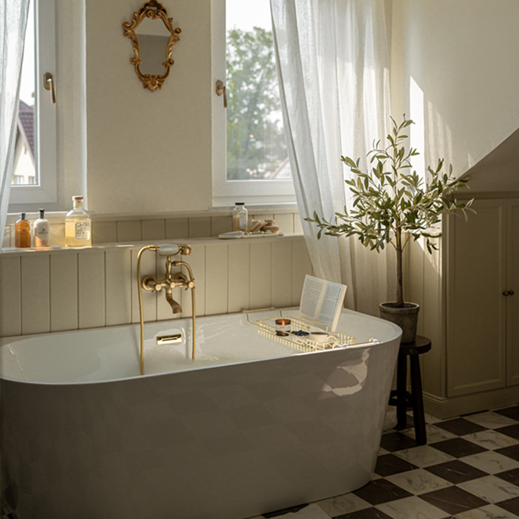 Vasca da bagno indipendente bianca con rubinetteria in ottone e specchio decorativo in bagno luminoso con pianta