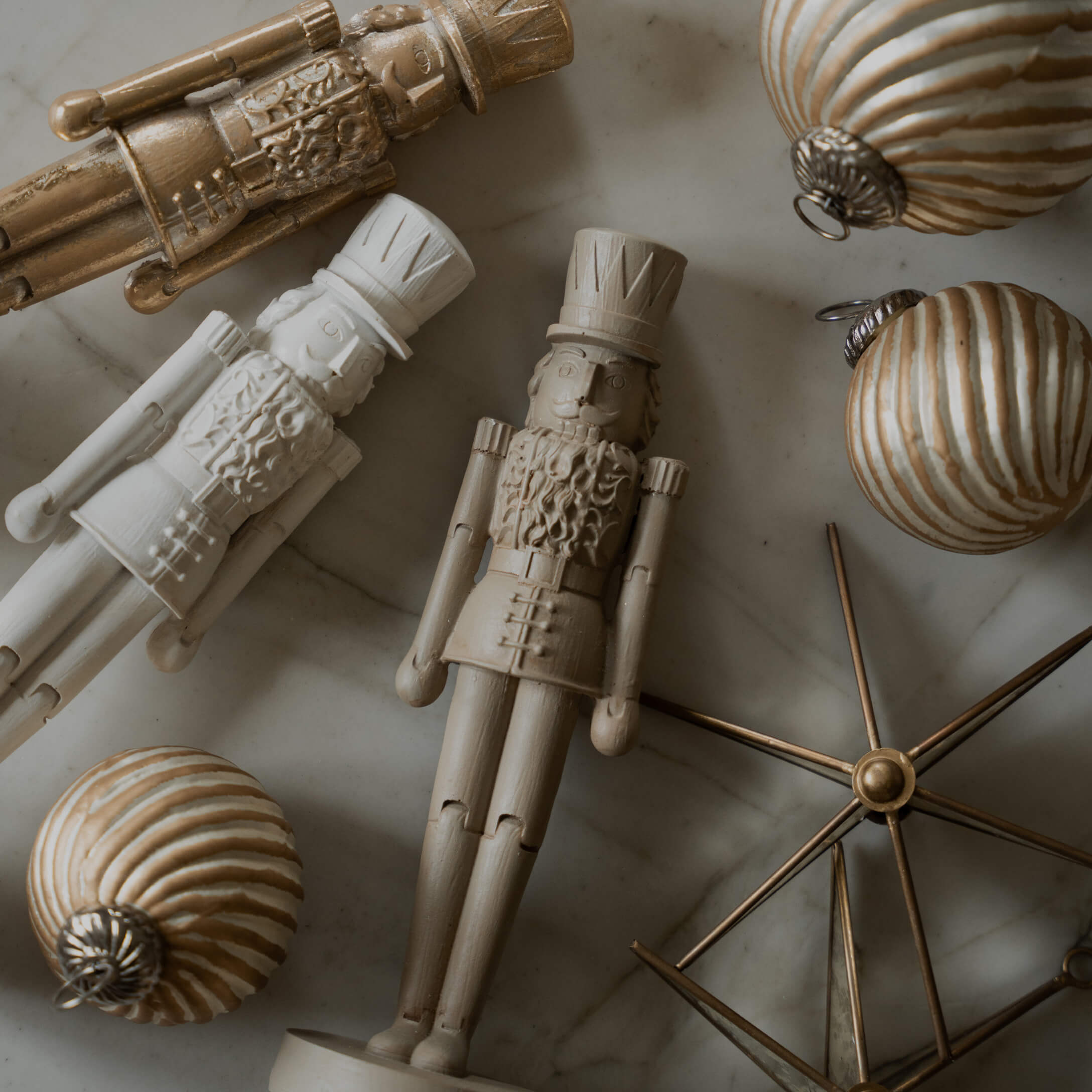Figure di soldati in legno e palline di Natale dorate su sfondo in marmo, decorazioni festive