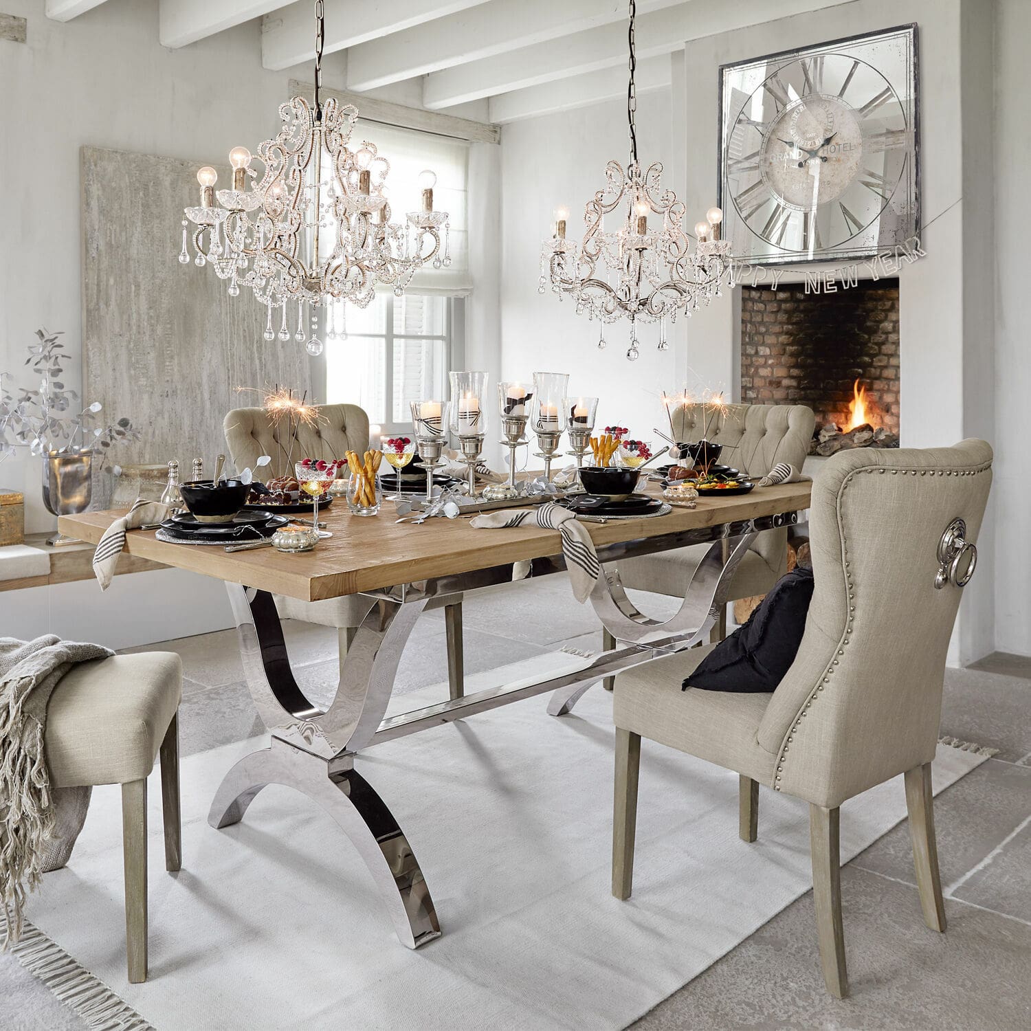 Tavolo Grover Sala da pranzo con tavolo in legno e sedie imbottite beige, decorazioni e lampadari di cristallo