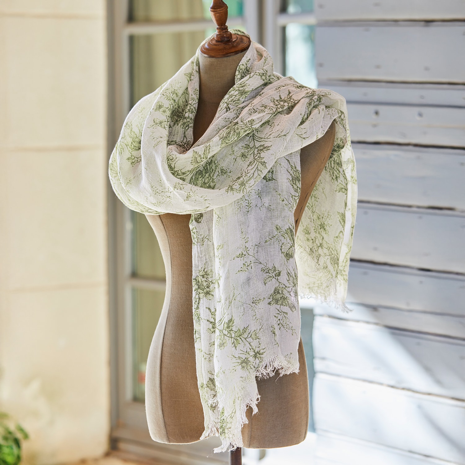 Sciarpa leggera con motivo floreale verde su fondo crema, decorazione da giardino con cesta in vimini
