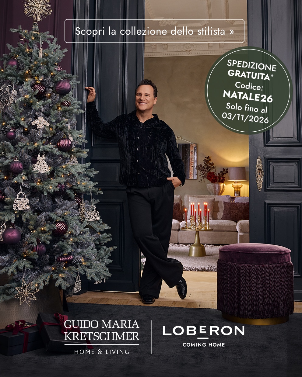 Uomo in abito nero accanto a un albero di Natale decorato con ornamenti viola in un interno elegante