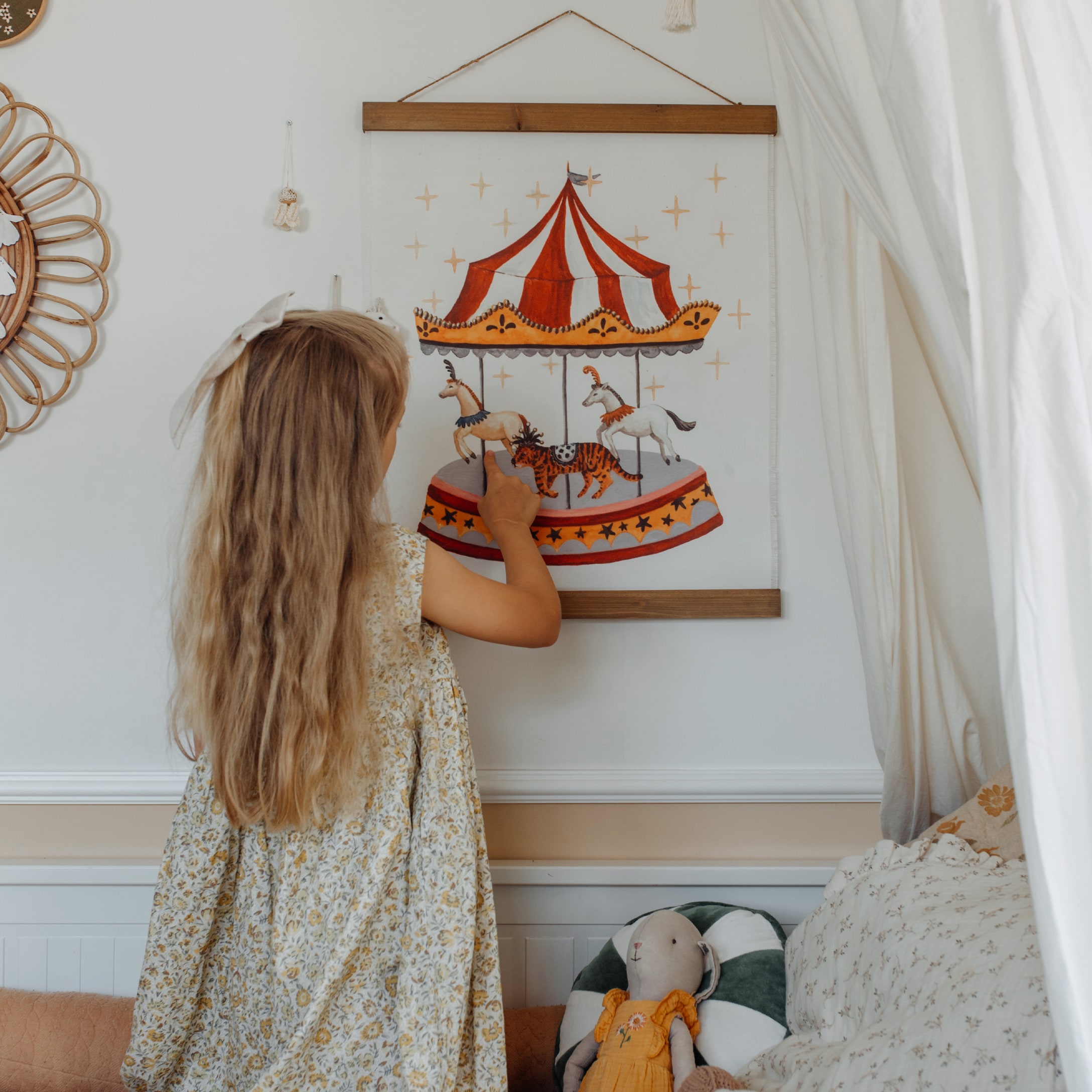 Bambino tocca decorazione da parete con carosello rosso e bianco in una cameretta accogliente