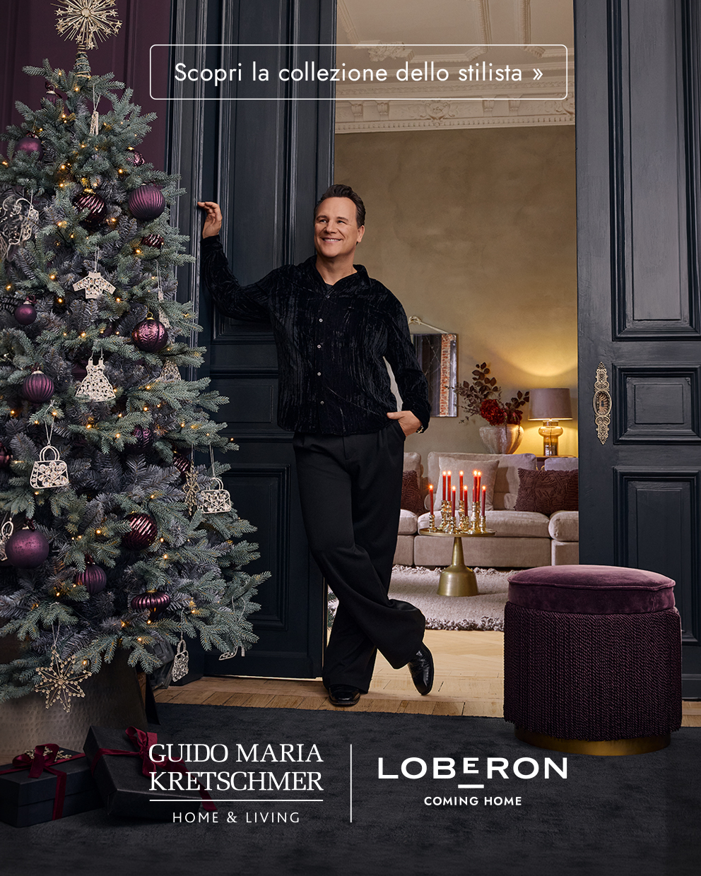 Uomo con abbigliamento nero accanto a un albero di Natale decorato con palline viola in un salotto elegante con decorazioni natalizie