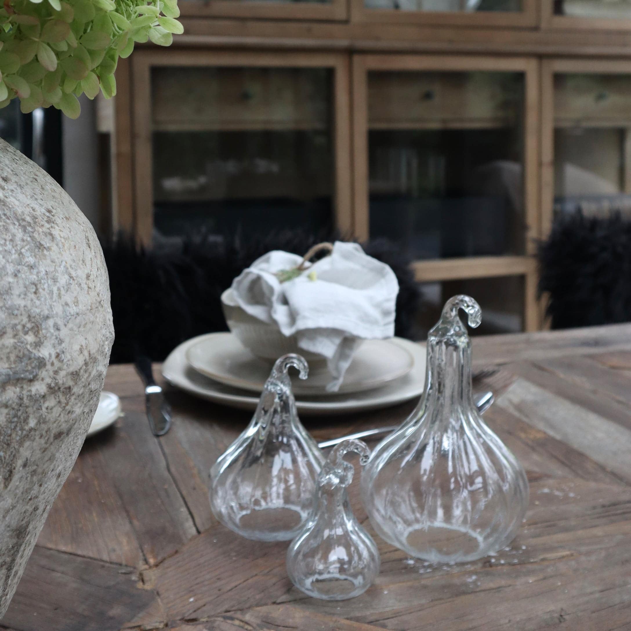 Decorazioni in vetro trasparente a forma di zucca su tavolo in legno in ambiente rustico
