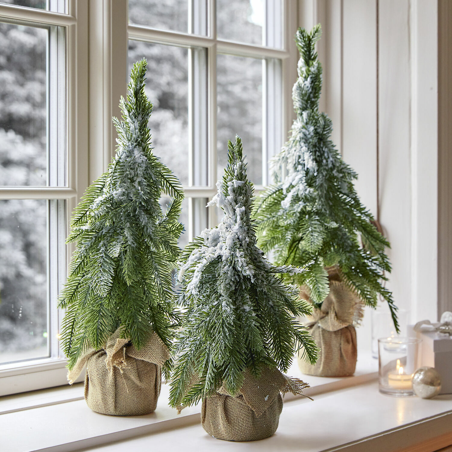 Set di 3 alberelli decorativi Selitor Tre alberi di Natale artificiali con rami verdi e neve finta in sacchi di juta sul davanzale