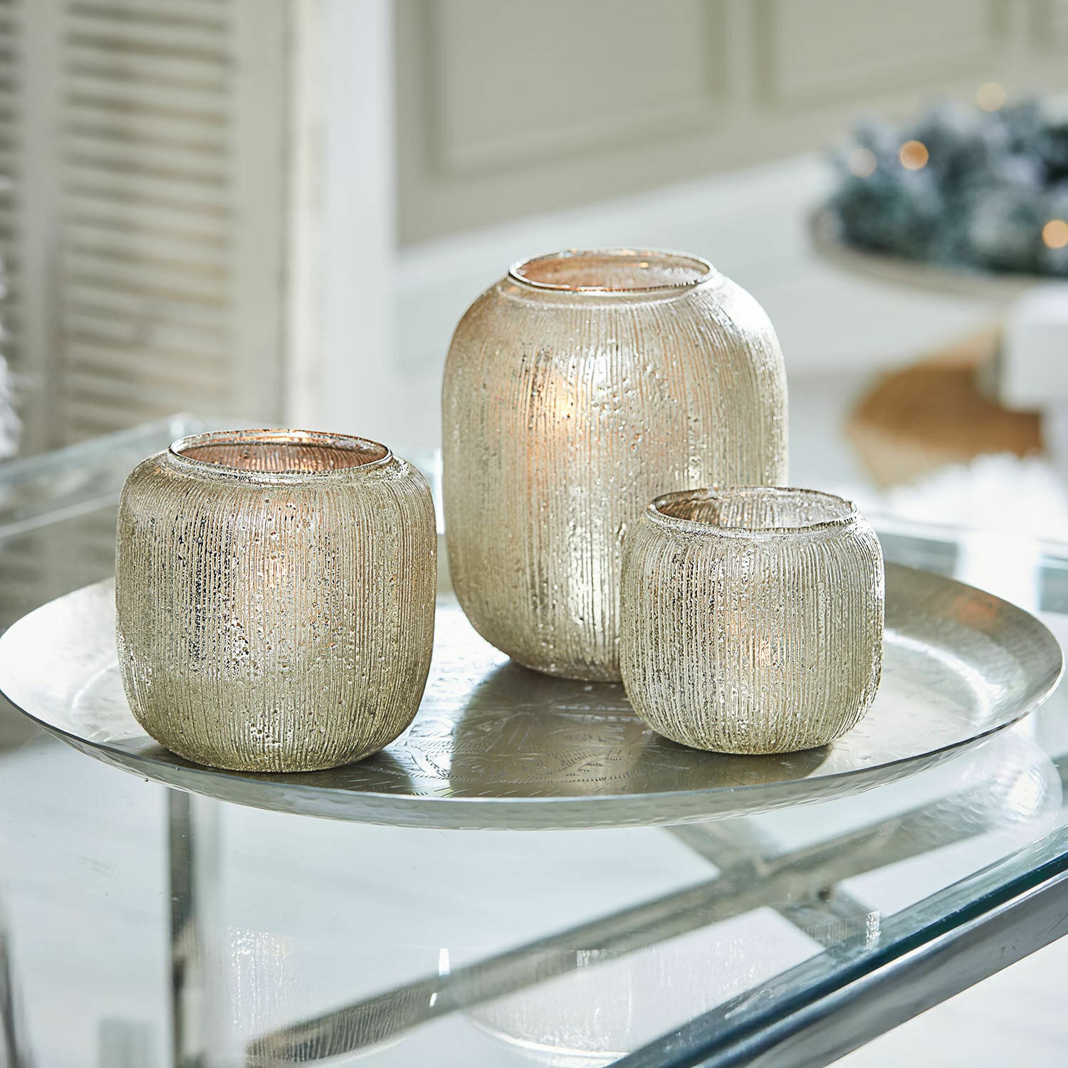 Set di 3 portalumini Clioneth Set di tre portacandele in vetro argentato con superficie strutturata su vassoio metallico