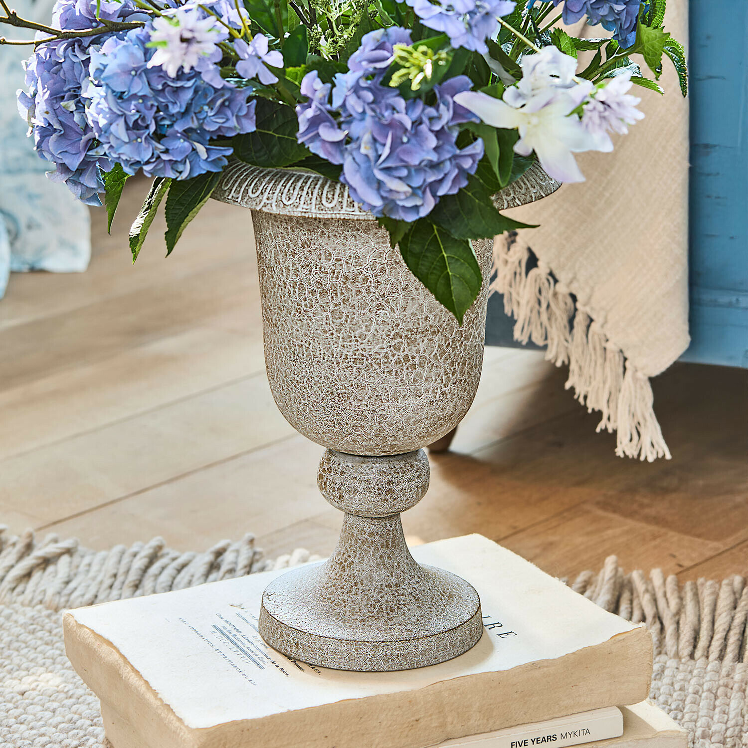 Vaso Vittoriane Vaso decorativo in ceramica beige invecchiata con fiori blu su libri antichi