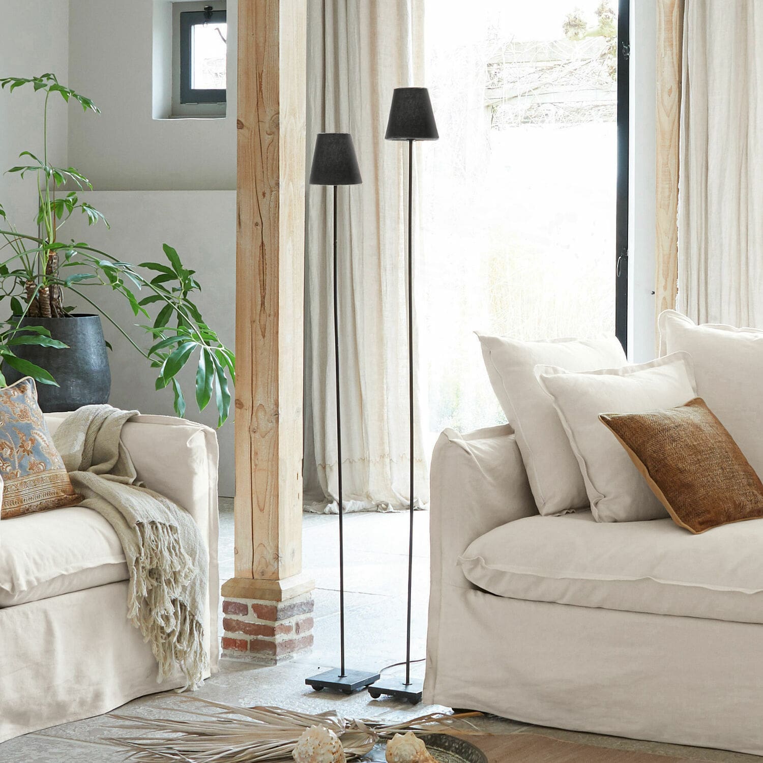 Coppia di lampade a stelo Tacoma Due lampade da terra in metallo nero in soggiorno luminoso con divano beige e pianta verde