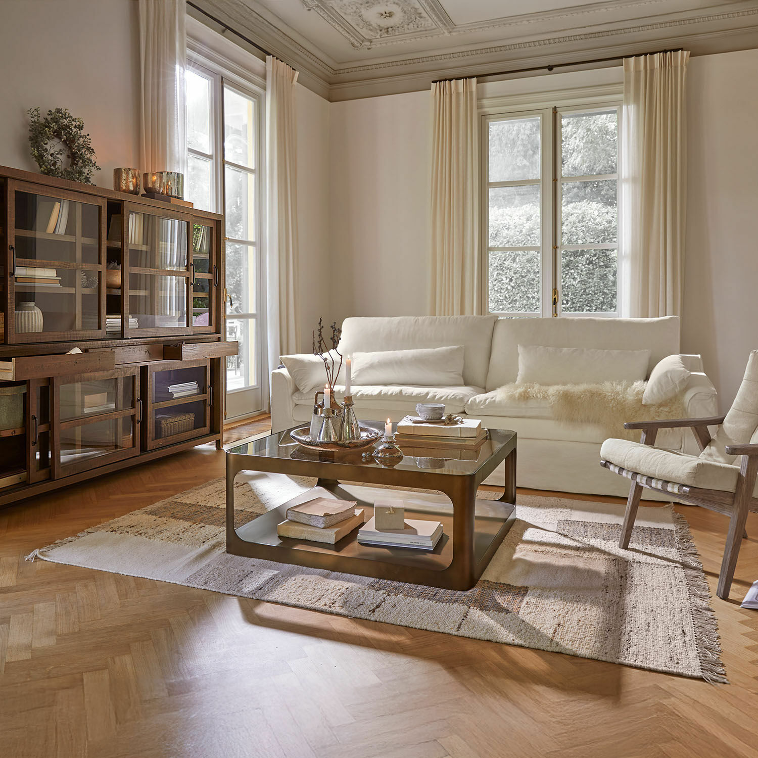 Tappeto Faircliffe Soggiorno accogliente con divano bianco, mobile in legno e tavolino in metallo su tappeto