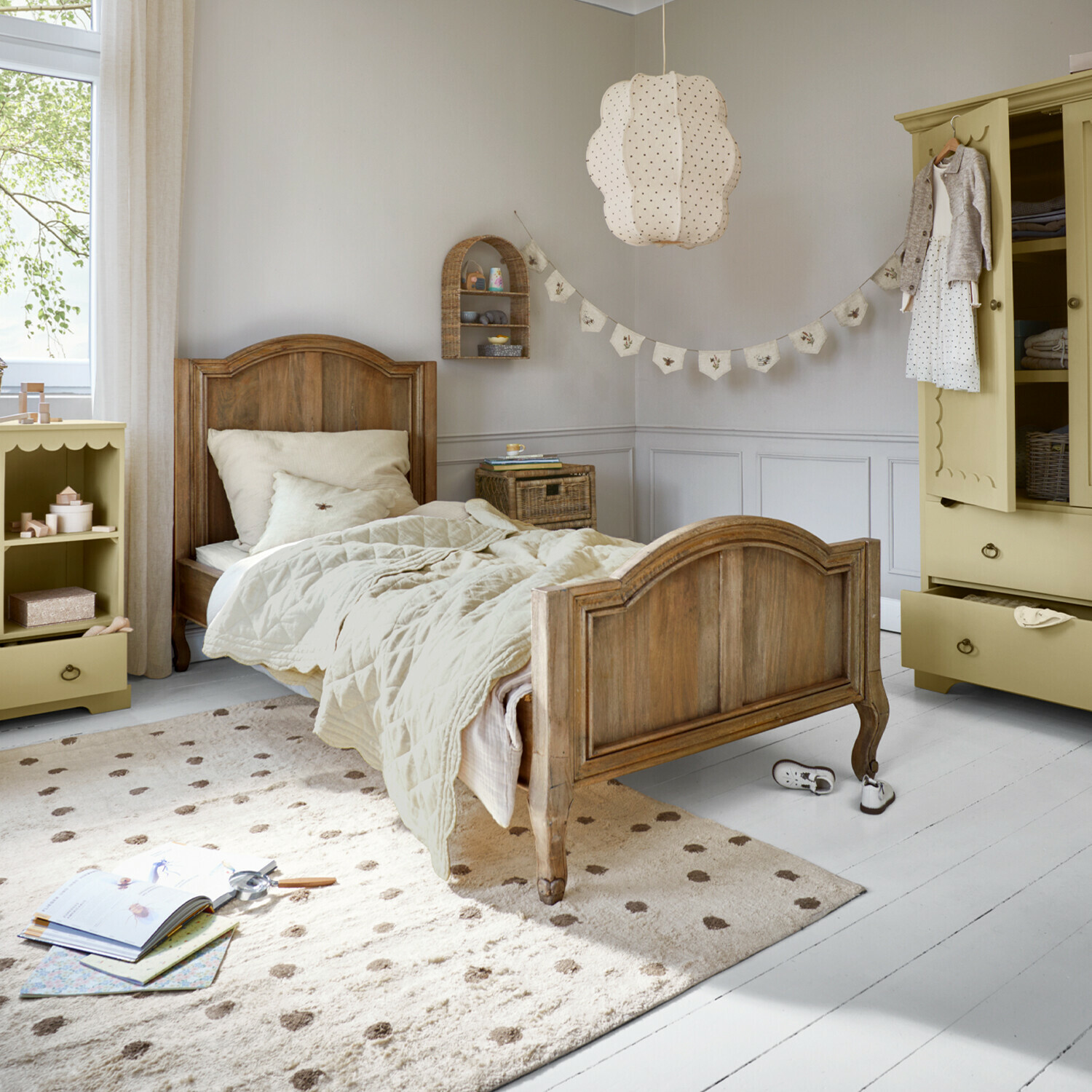 Letto Rêverine Letto per bambini in legno con biancheria beige e tappeto crema in stanza luminosa per bambini