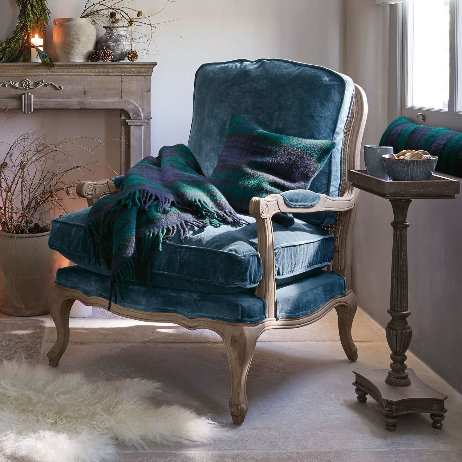 Poltrona in velluto blu con struttura in legno chiaro, coperta e cuscino verde e blu scuro