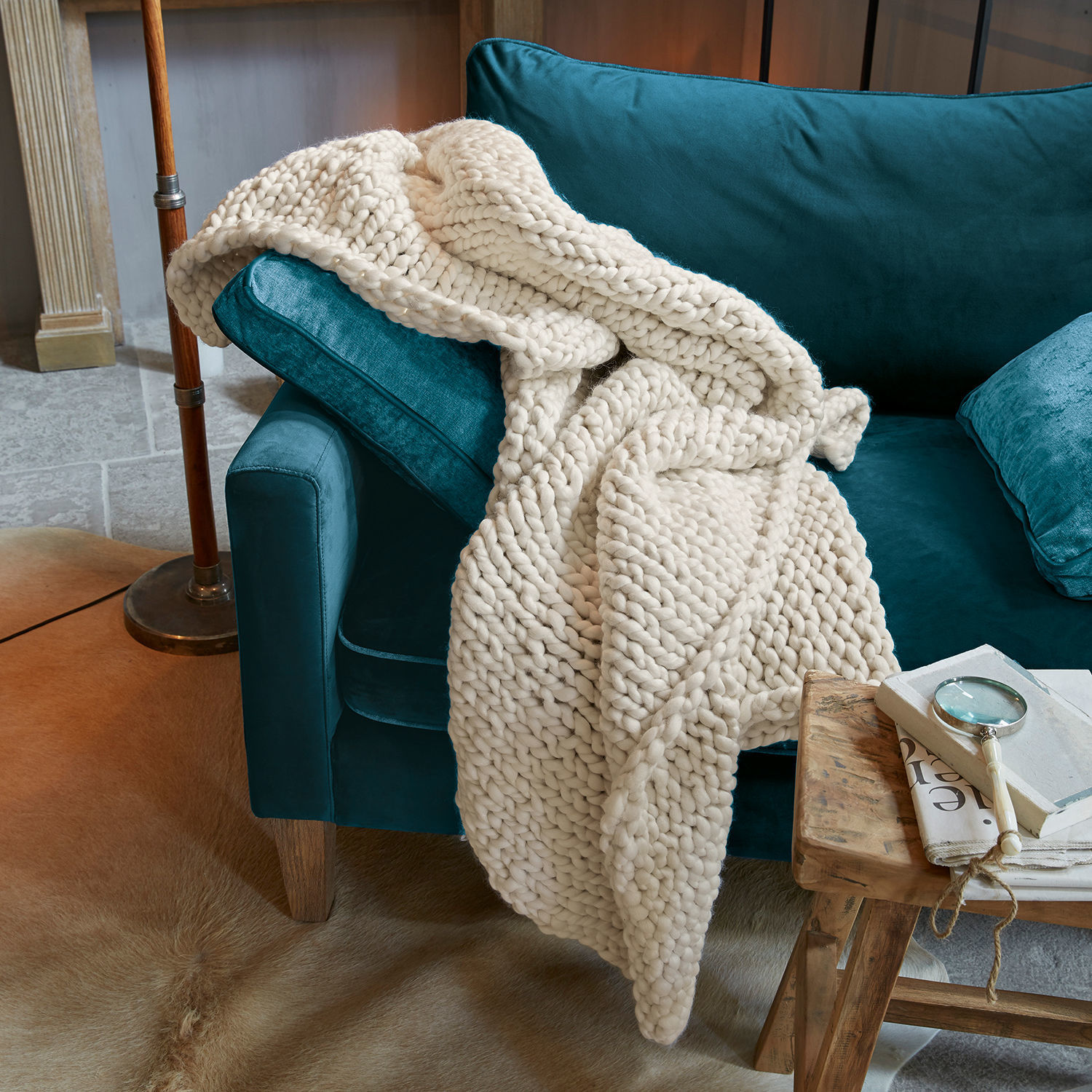 Coperta Reidous Coperta spessa in lana color crema su divano in velluto turchese in ambiente accogliente