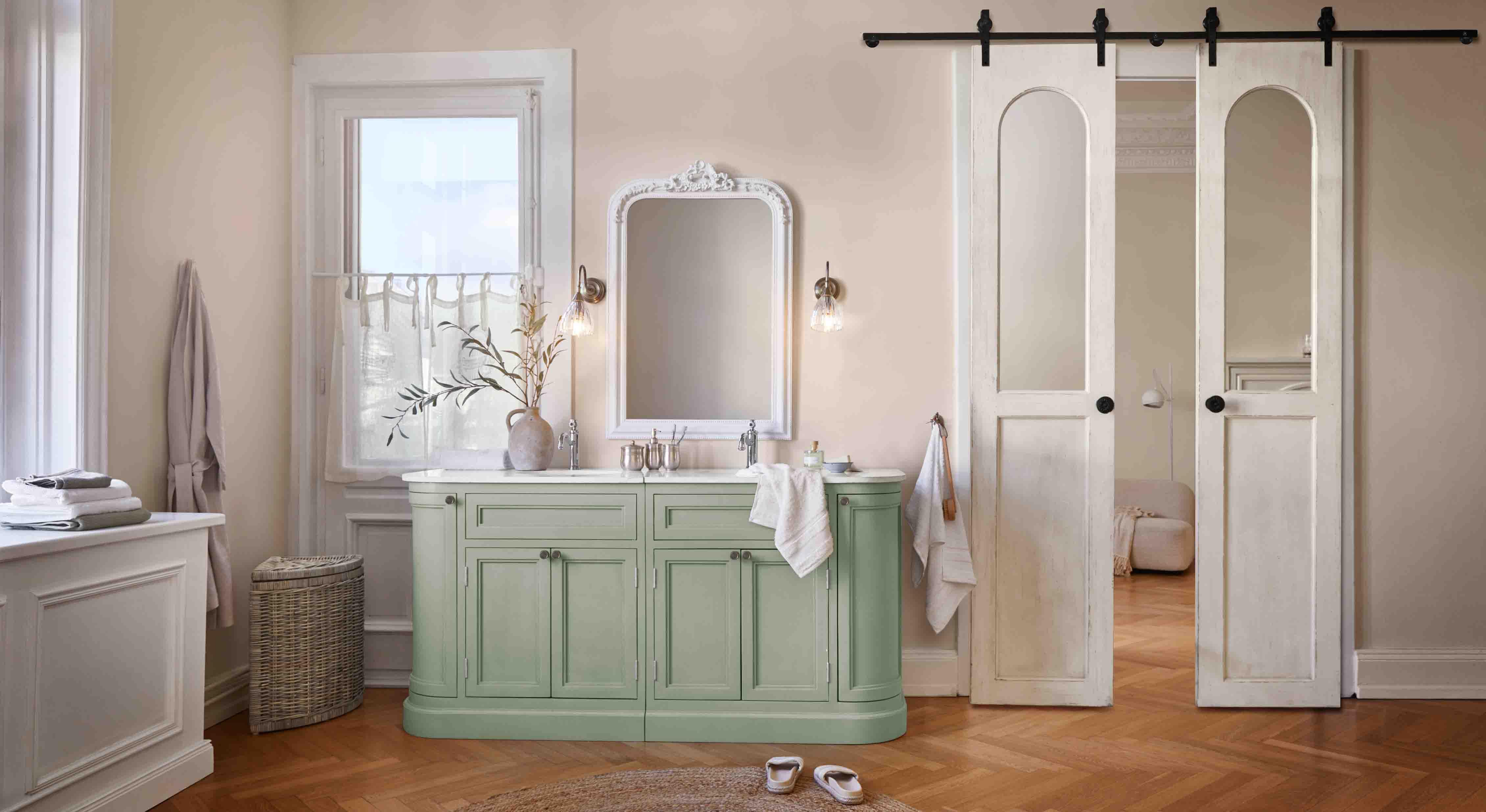 Mobile bagno verde con piano bianco e specchio vintage decorativo in cornice intagliata