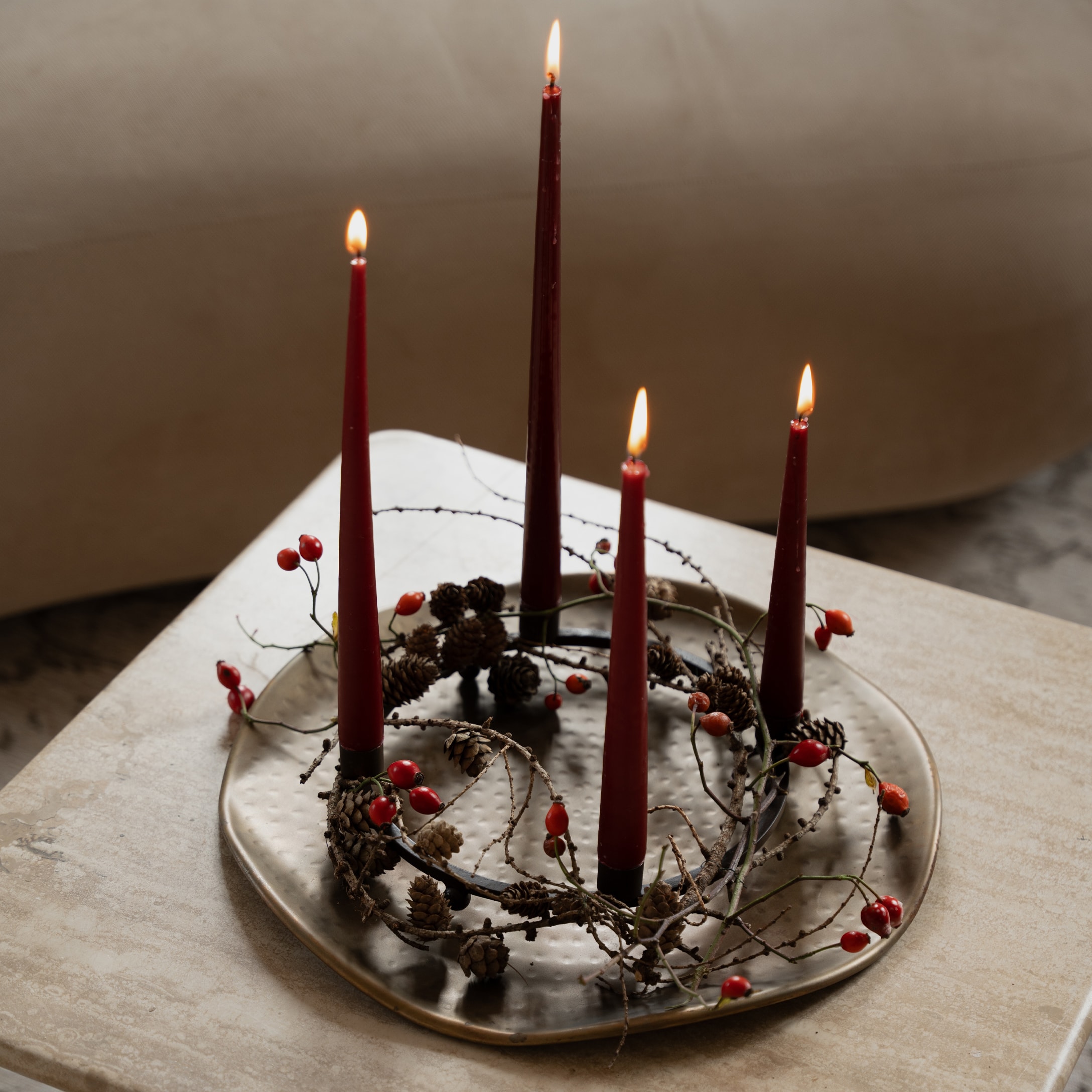 Corona d'Avvento decorativa con candele rosse e pigne naturali su base metallica