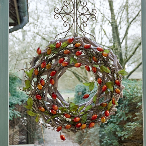 Corona decorativa di rami con bacche rosse, decorazione autunnale per porta d'ingresso