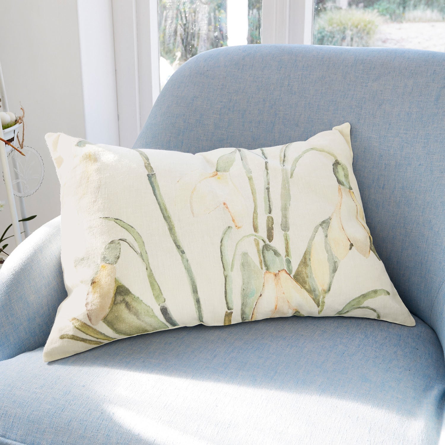 Copricuscino Willmare Cuscino decorativo rettangolare in cotone crema con motivi floreali verdi e gialli su poltrona azzurra