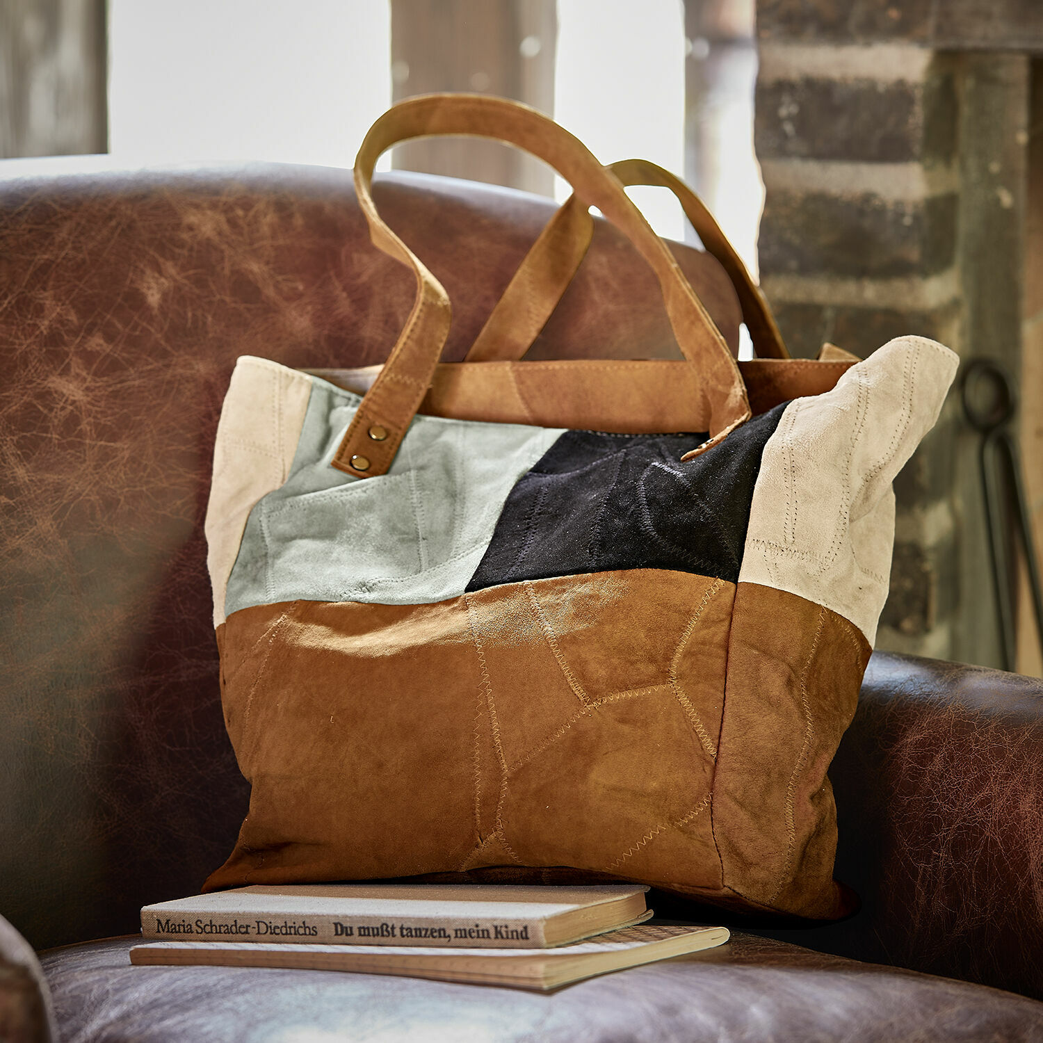 Borsa Quinvelle Borsa patchwork in camoscio marrone, nero e beige su poltrona in pelle marrone