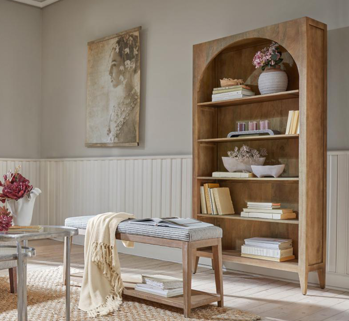 Libreria in legno con arco, decorazioni e libri in soggiorno luminoso e naturale