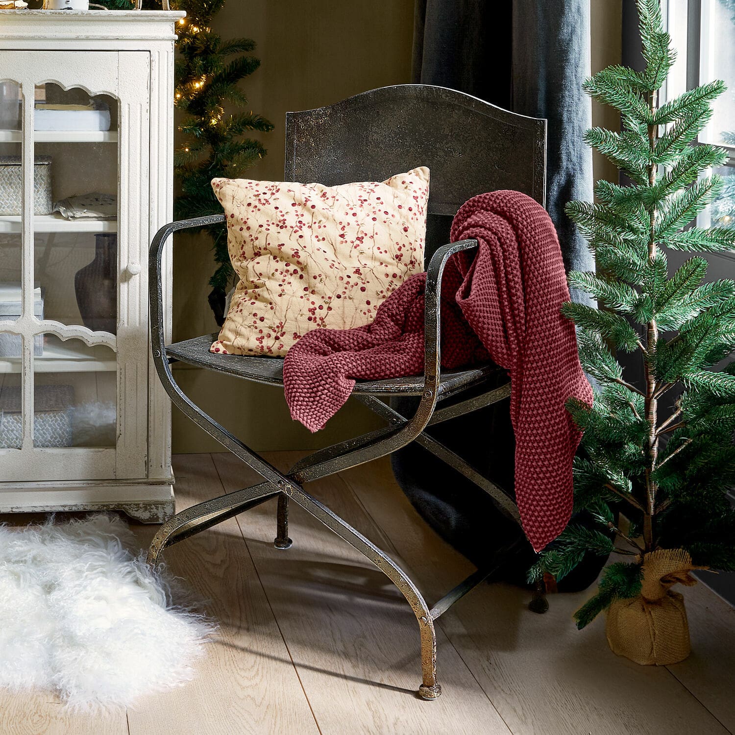 Sedia Ivilique Sedia in metallo con cuscino a bacche rosse e coperta bordeaux in ambiente accogliente con albero di Natale
