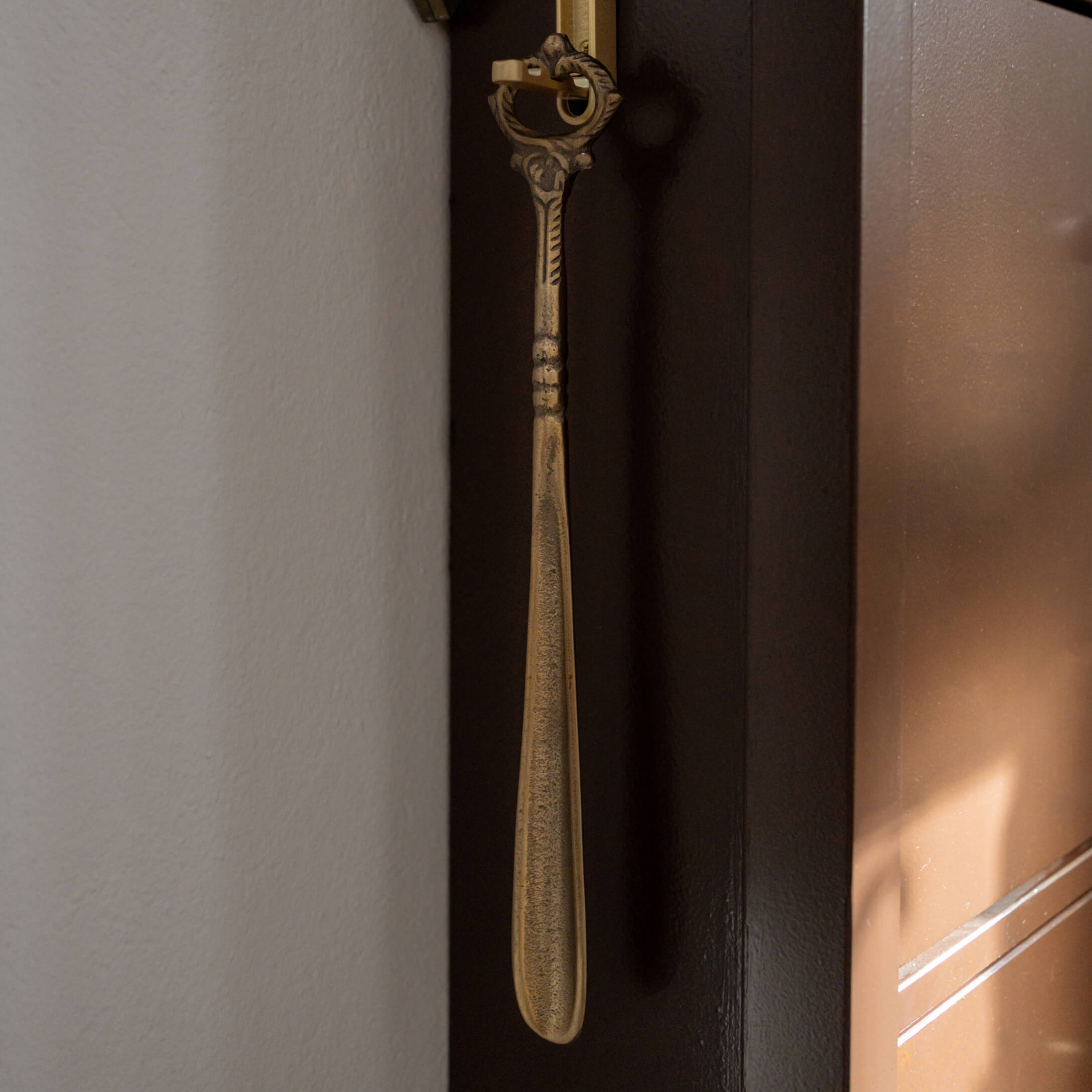 Calzascarpe in metallo dorato con manico decorativo, strumento pratico per la casa