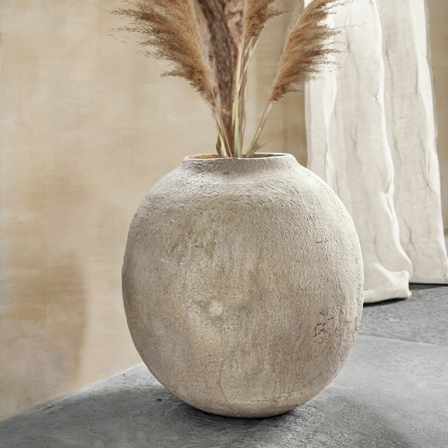Vaso Samai Vaso rotondo in cemento grigio con erbe decorative in un interno moderno