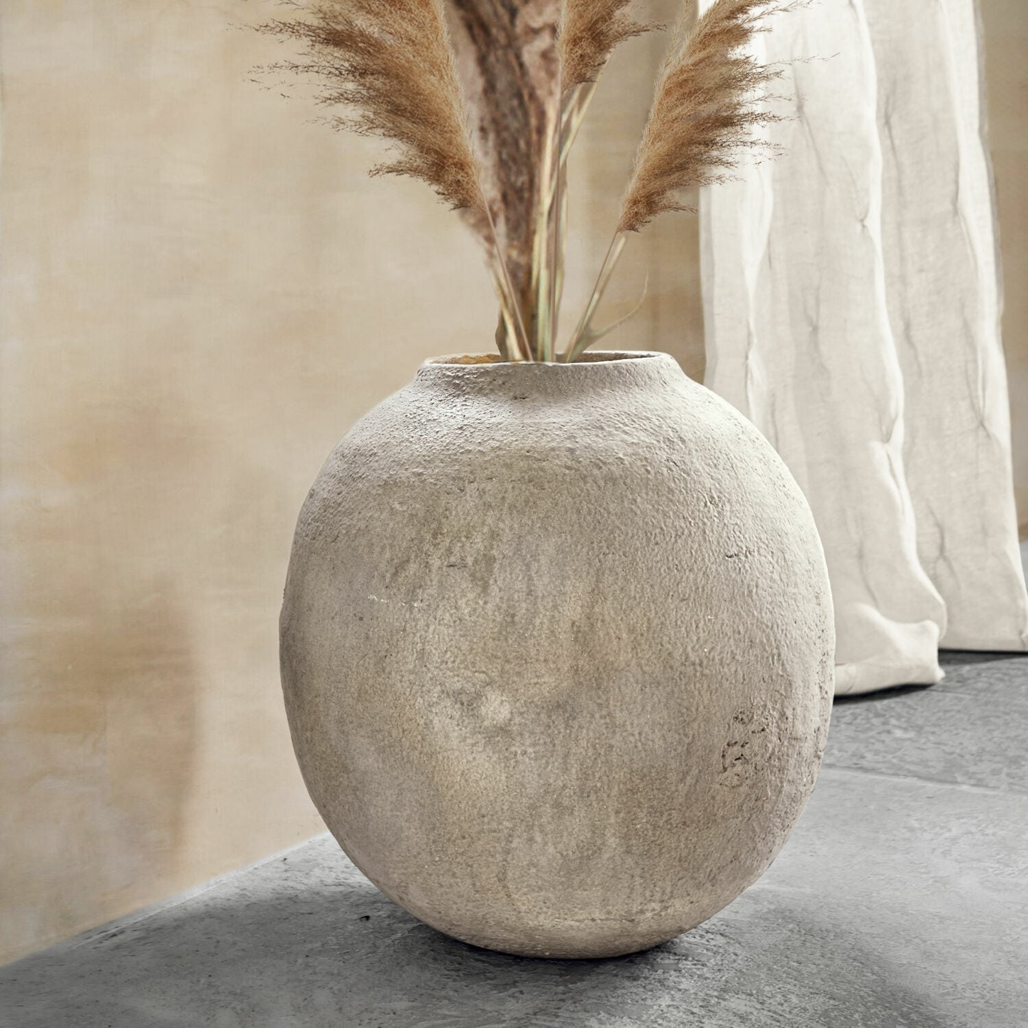 Vaso Samai Vaso rotondo in cemento grigio con erbe decorative in un interno moderno