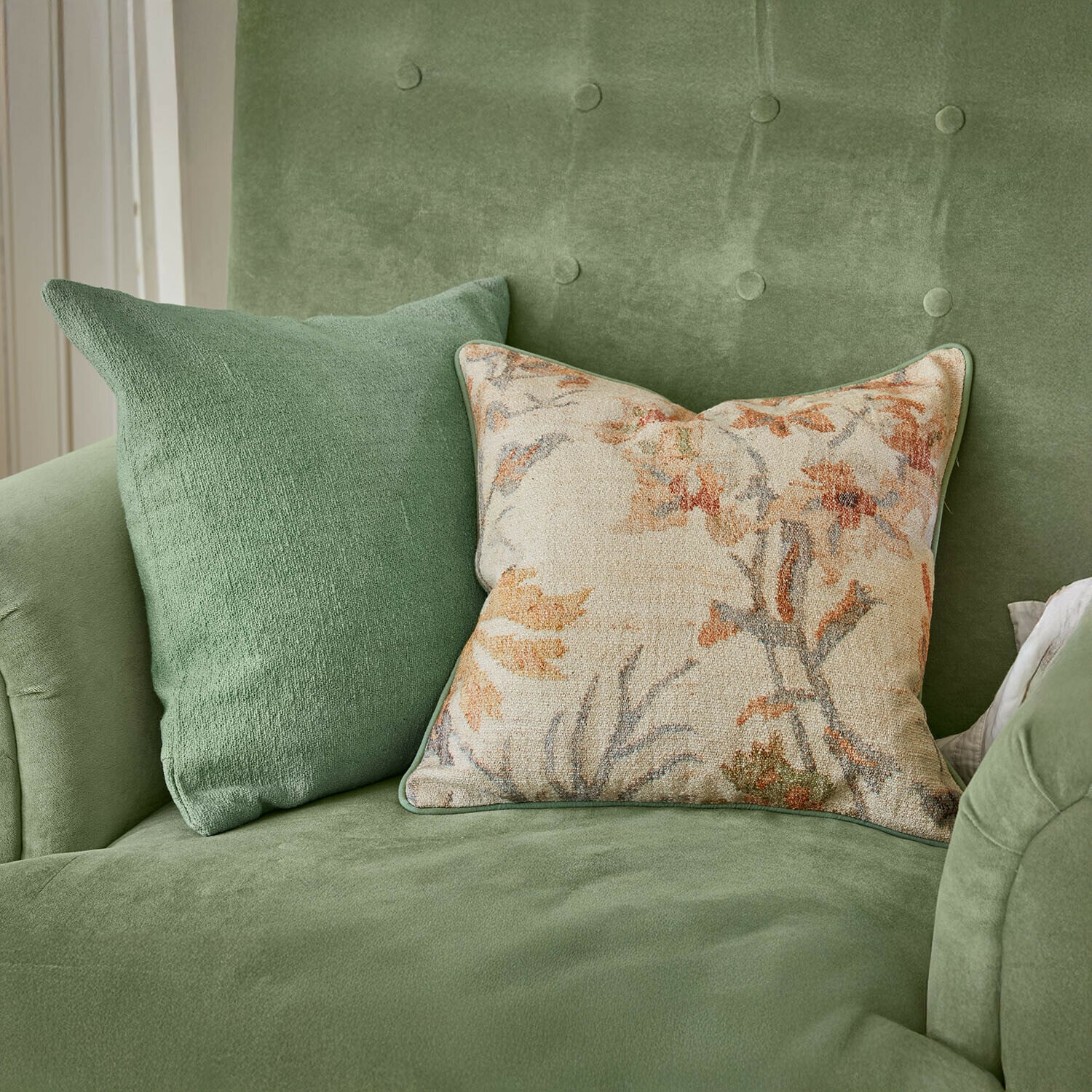 Coppia di copricuscini Osorno Divano verde in velluto con due cuscini, uno tinta unita e uno con motivo floreale, decorazione elegante