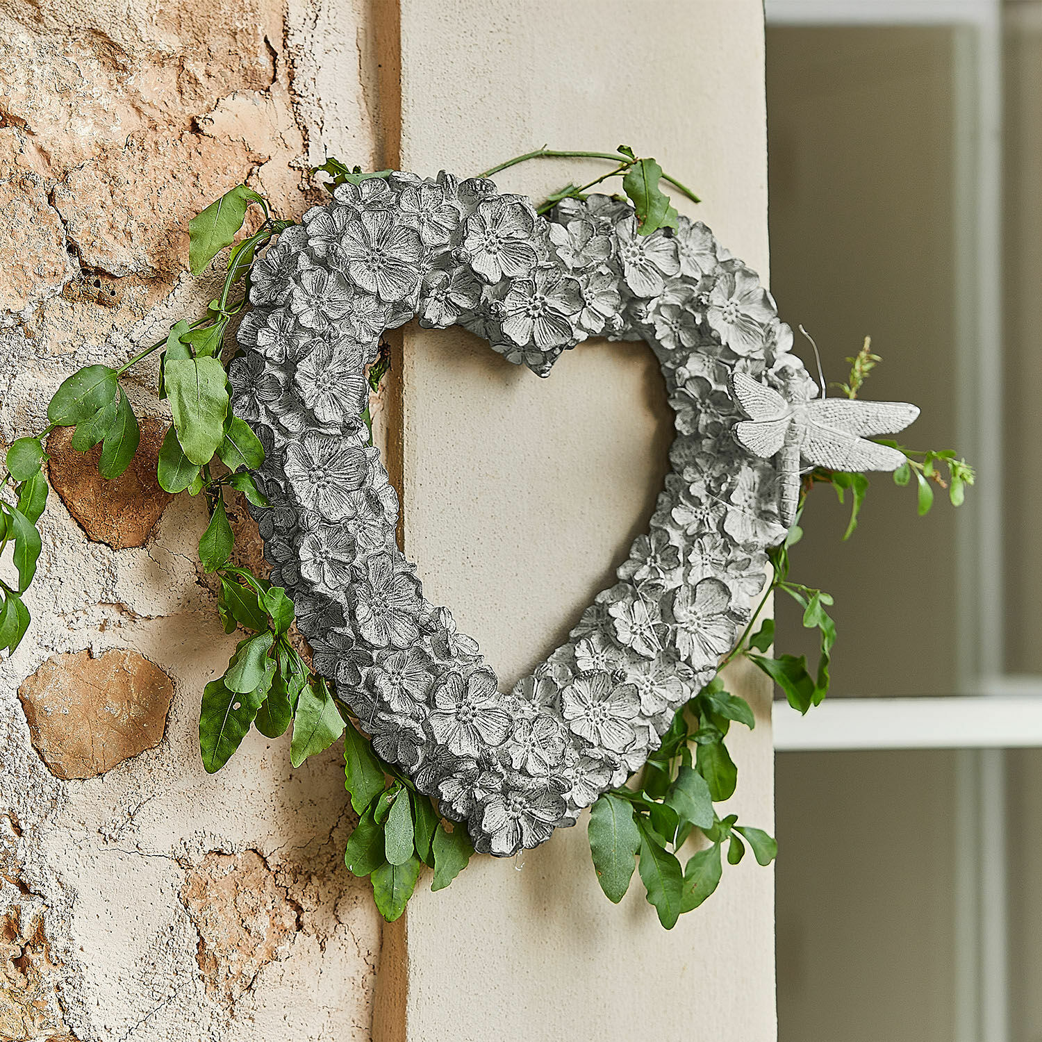 Ghirlanda Corvelique Cuore decorativo in metallo grigio con fiori, foglie verdi e libellula da appendere al muro