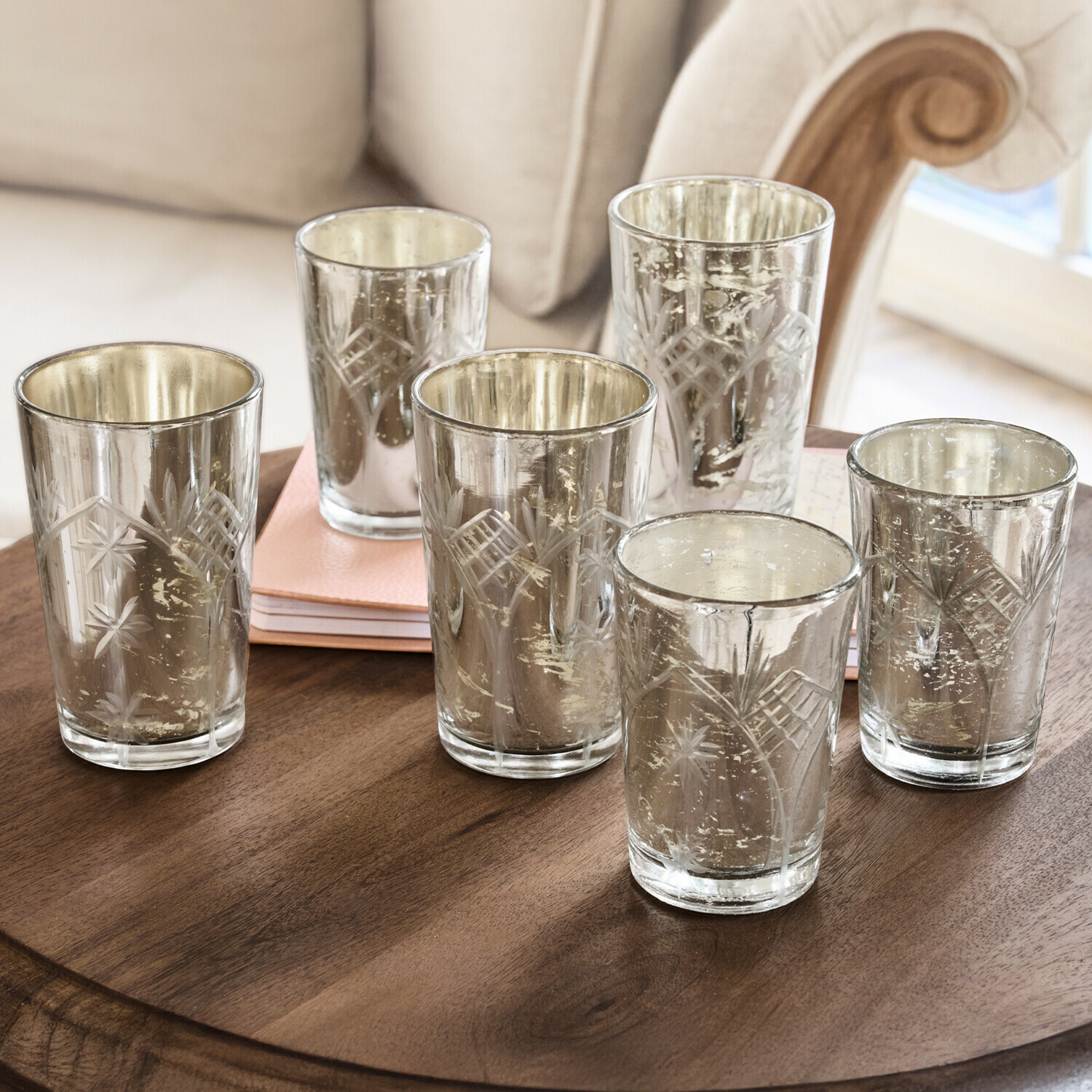 Set di sei portacandele in vetro inciso con finitura argentata su tavolo in legno