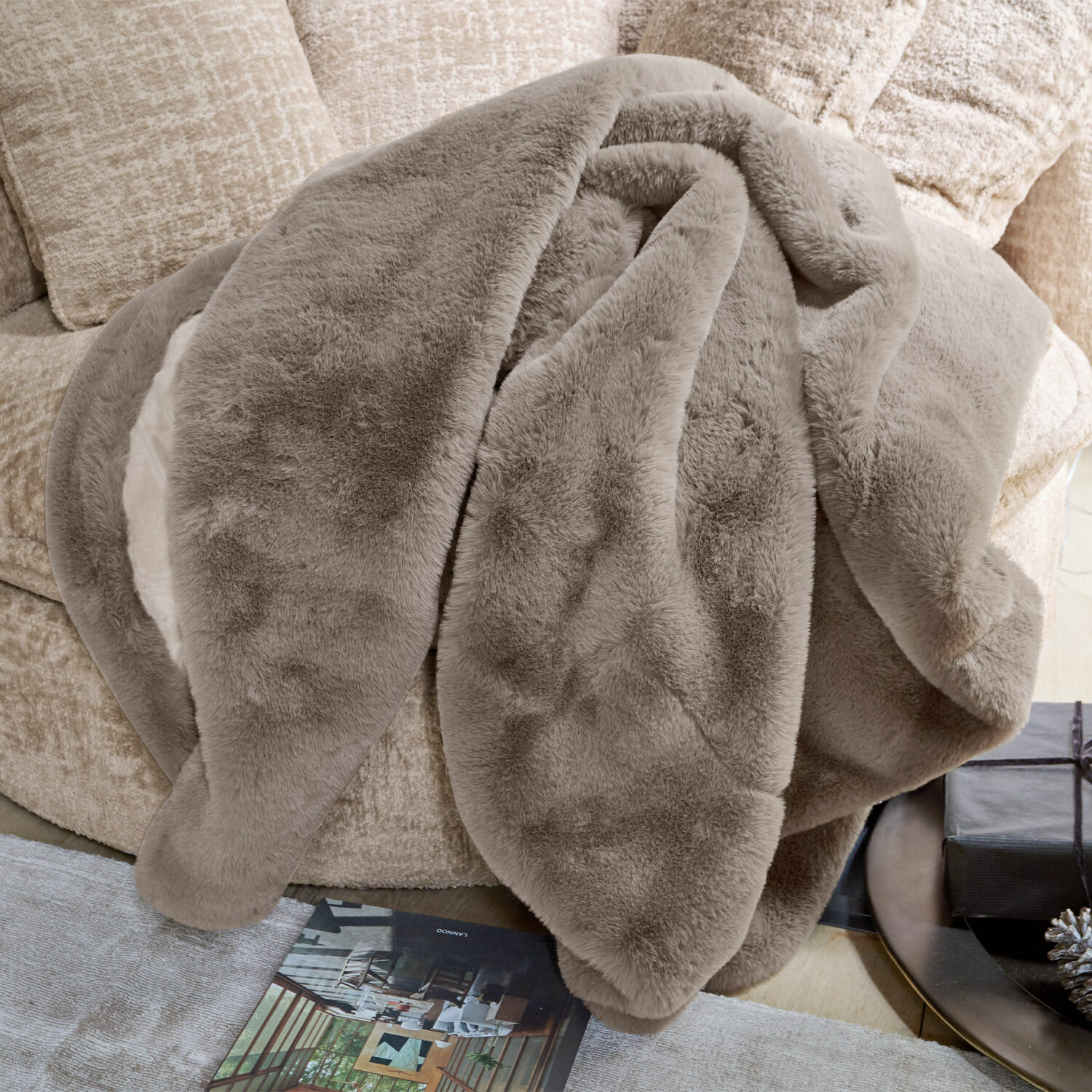 Coperta Brisvento Morbida coperta beige in pelliccia sintetica su divano, ideale per un ambiente accogliente