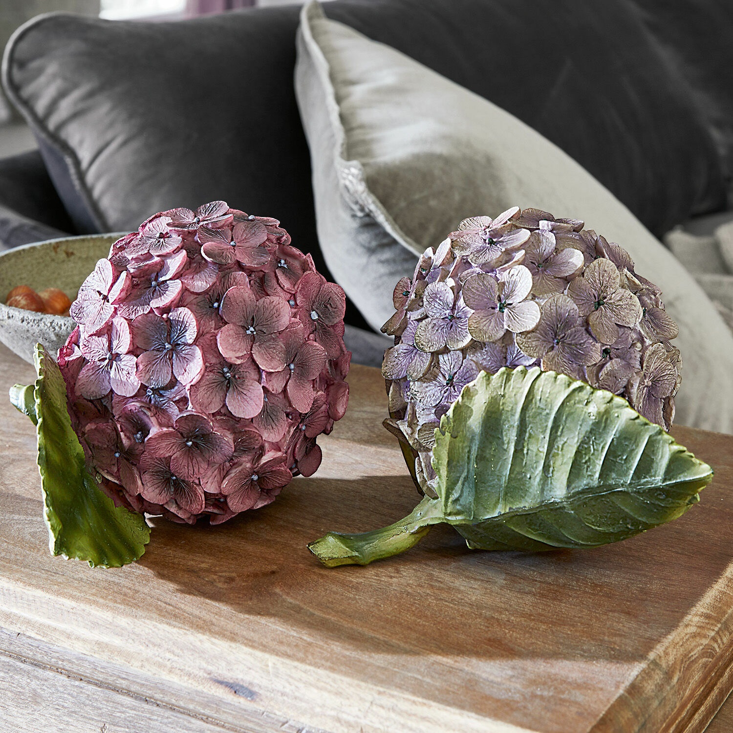 Coppia di fiori decorativi Hortensie Sfere decorative di ortensia rosa e viola con foglie verdi su tavolo in legno per arredamento