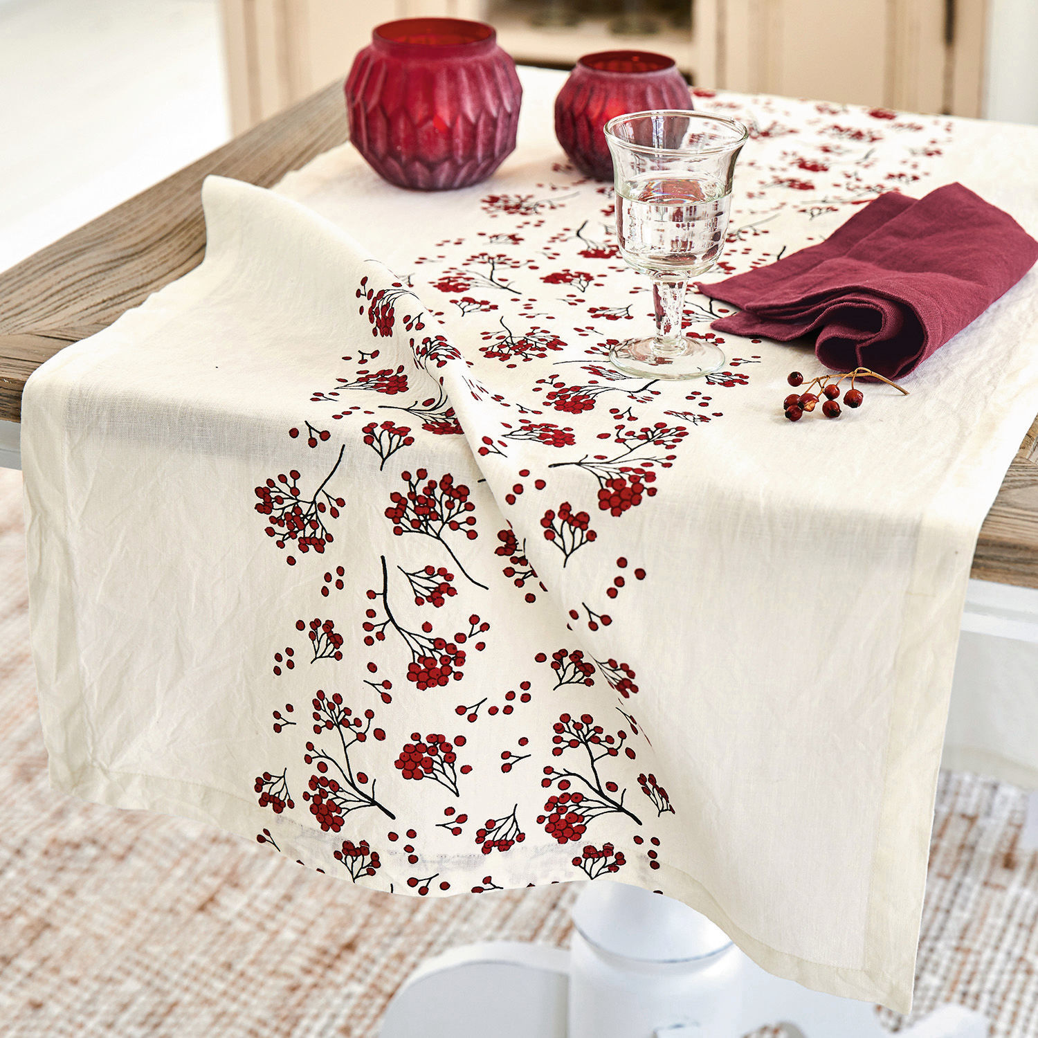 Runner Vestré Tovaglia in lino color crema con motivo di bacche rosse su tavolo in legno con decorazioni