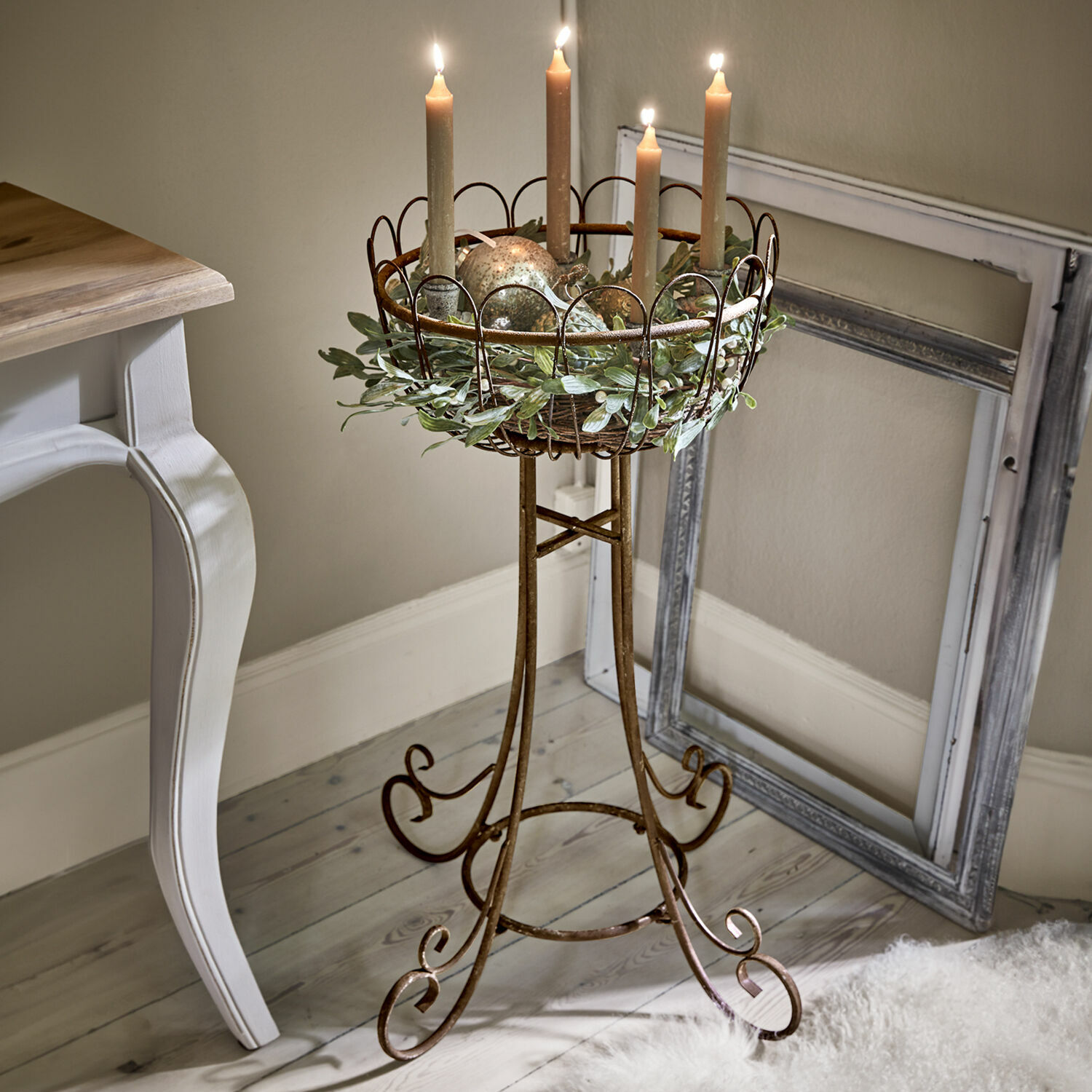 Supporto per decorazioni Évariste Portacandele in metallo marrone con corona decorativa e quattro candele accese in ambiente interno