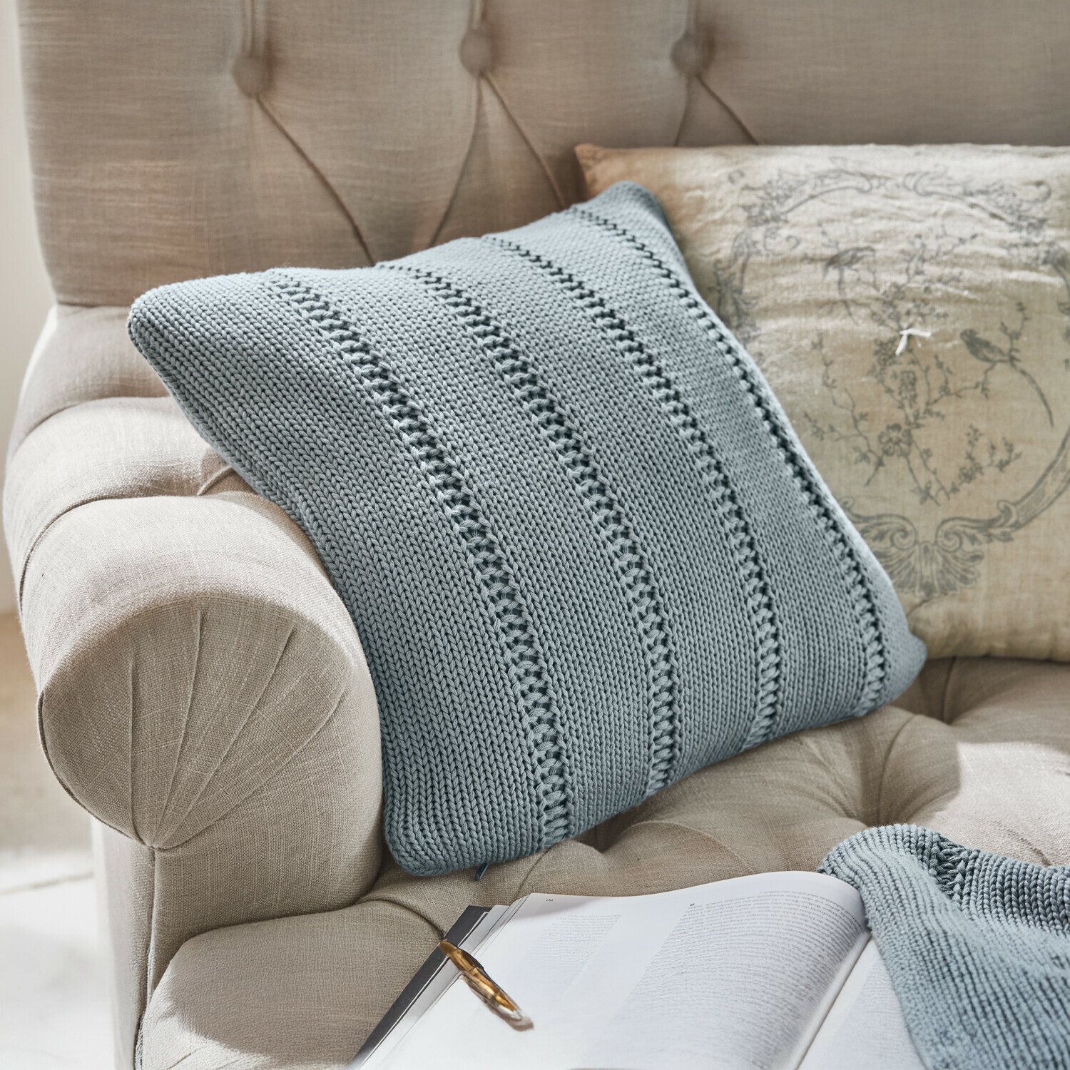 Copricuscino Lémeré Poltrona beige imbottita in tessuto con schienale capitonné, coperta lavorata a maglia grigia e cuscino