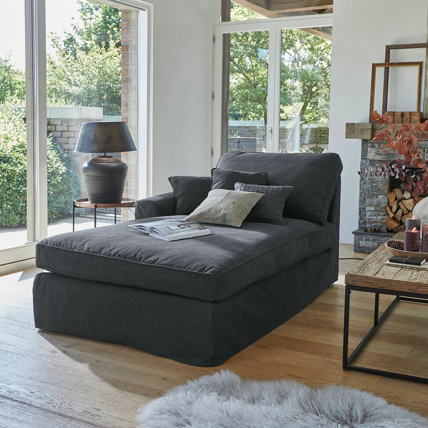 Chaise-longue Seaford Chaise longue imbottita grigio scuro con cuscini in soggiorno moderno con pavimento in legno