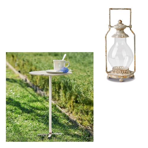 Tavolino da giardino in metallo chiaro con tazza e fiore sull'erba, mobili da esterno